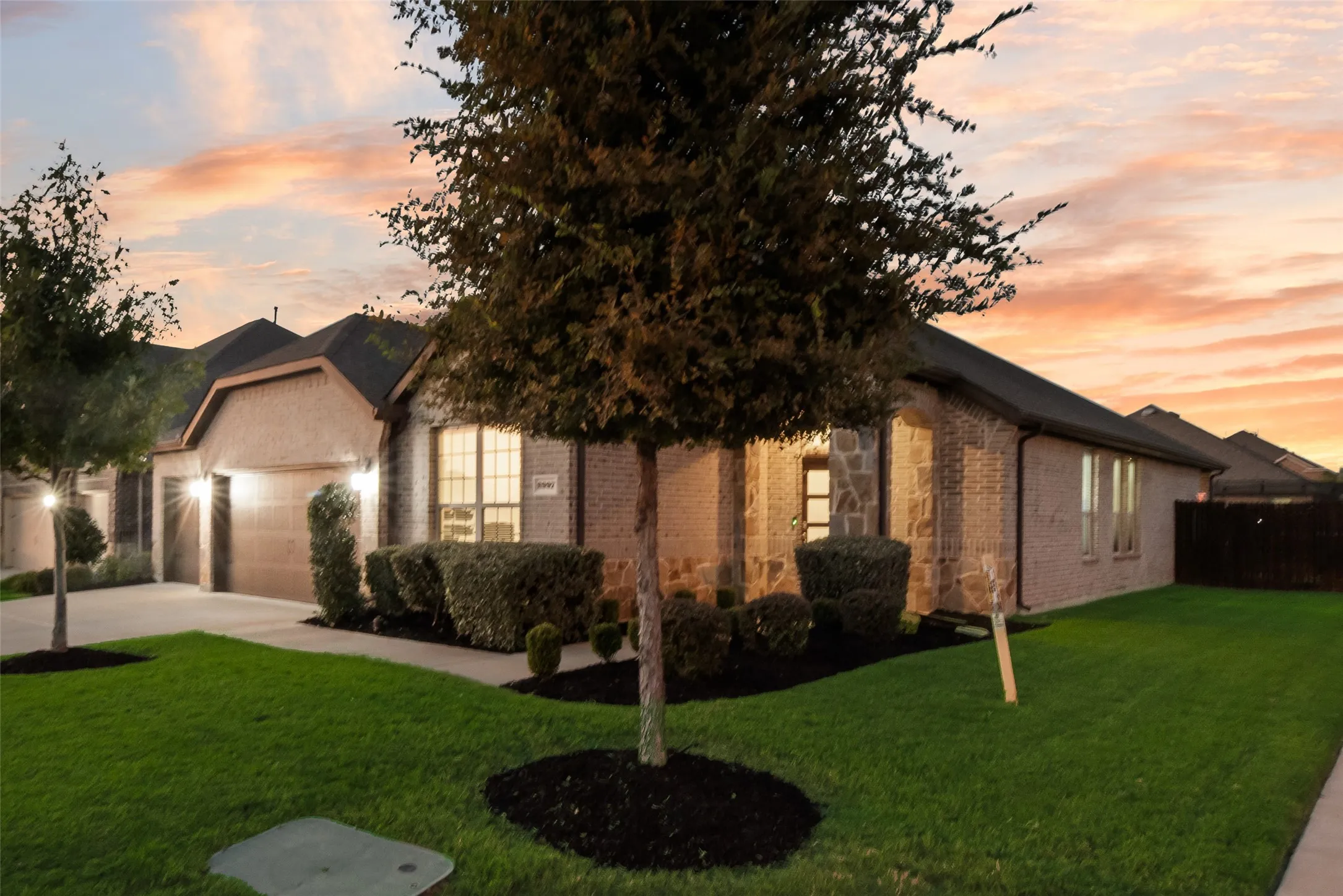 Obstructed view of property with brick siding, driveway, and an attached garage
