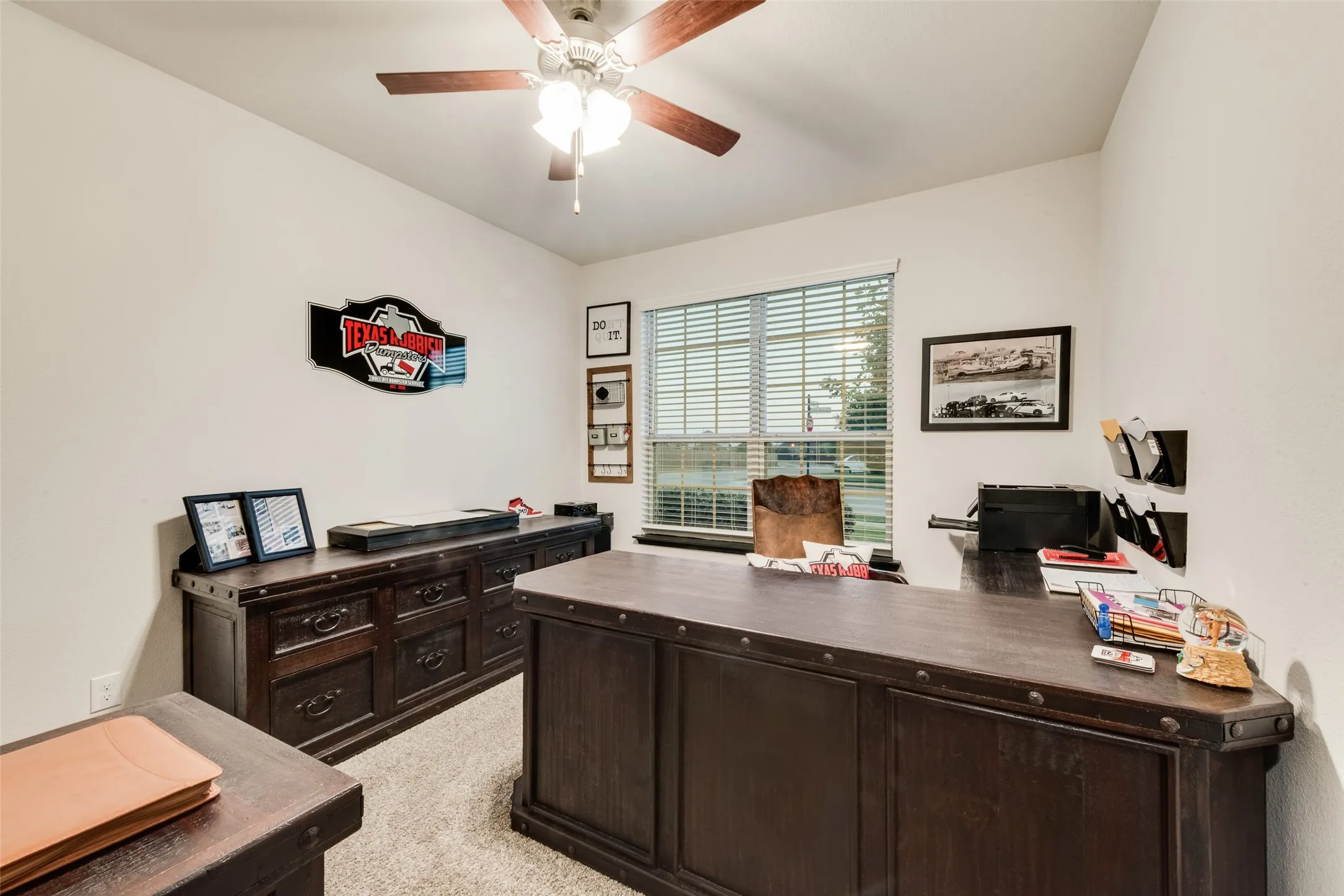 Office space with light carpet and ceiling fan