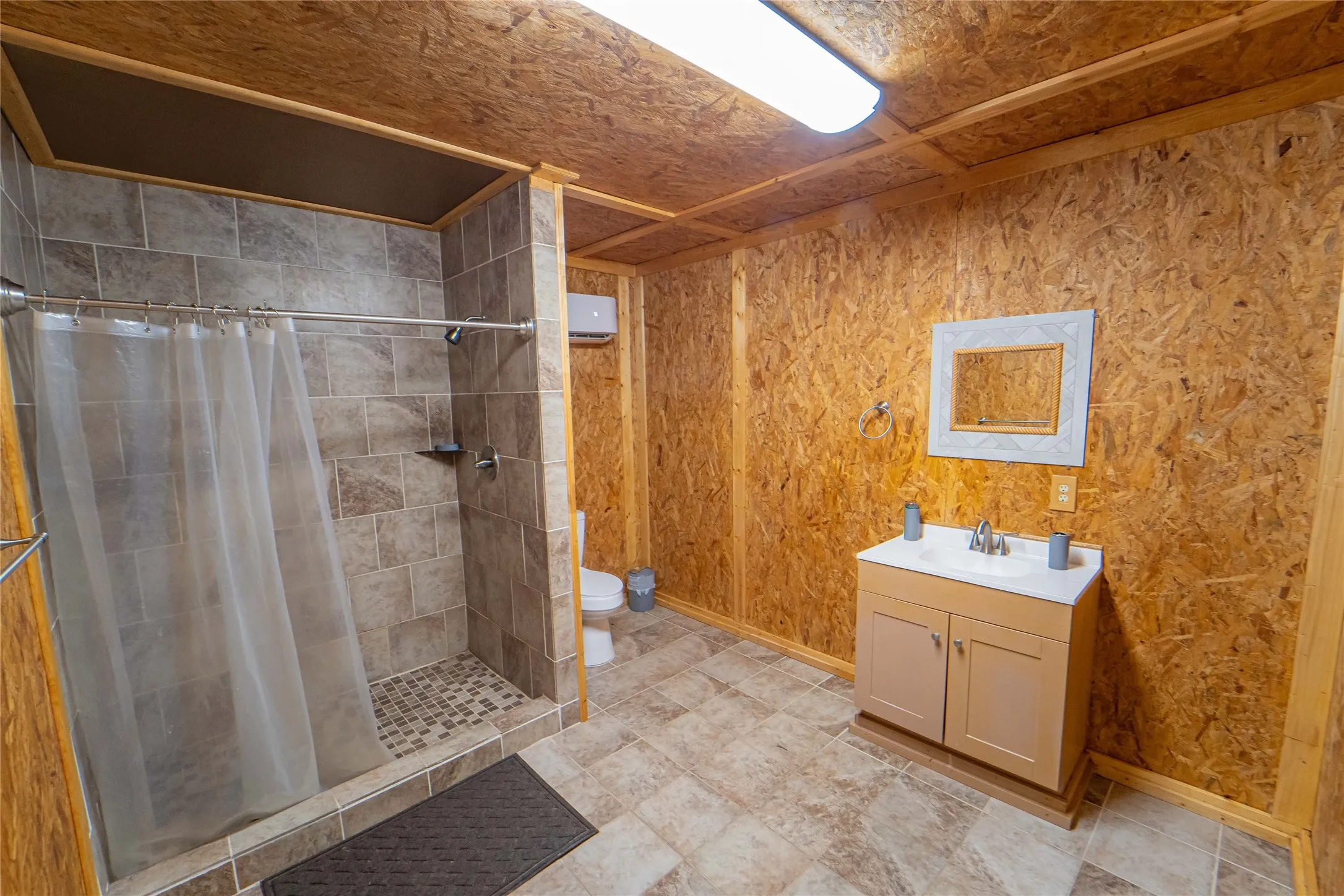 Full bathroom with vanity, a stall shower, and a wall mounted air conditioner