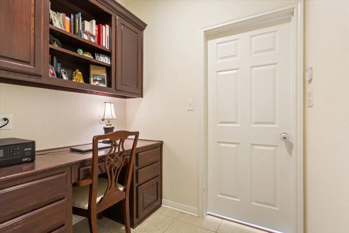 Home office featuring built in desk and light tile patterned flooring