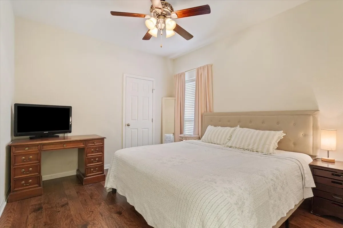 Bedroom featuring dark wood-type flooring and a ceiling fan