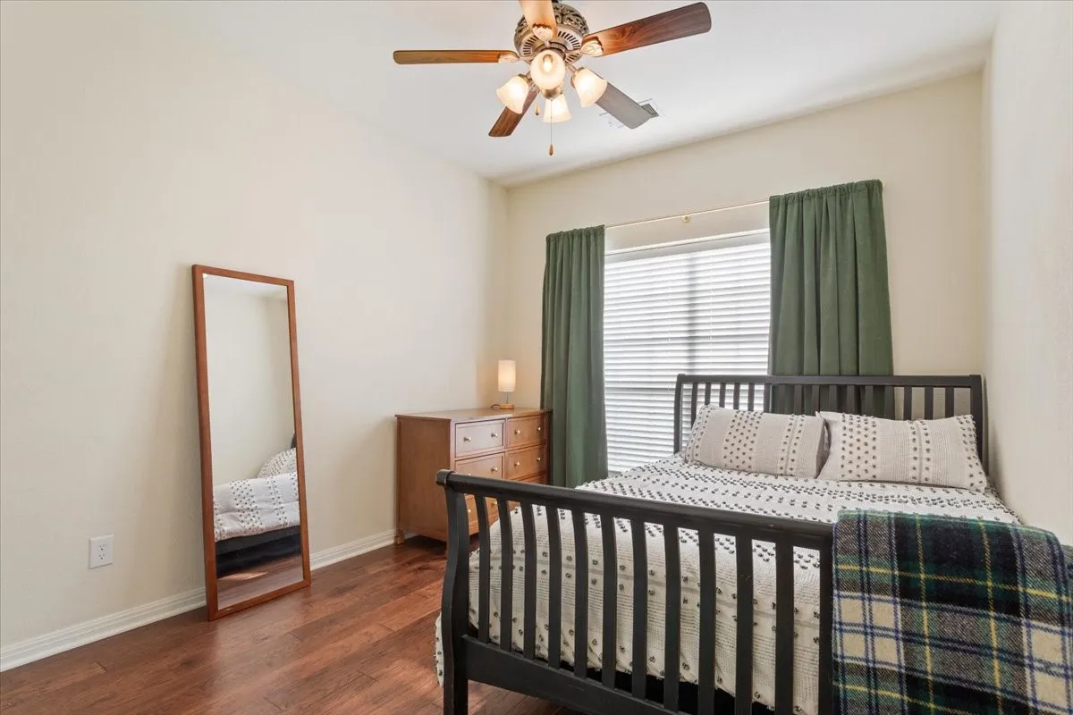 Bedroom featuring dark wood-style floors and ceiling fan