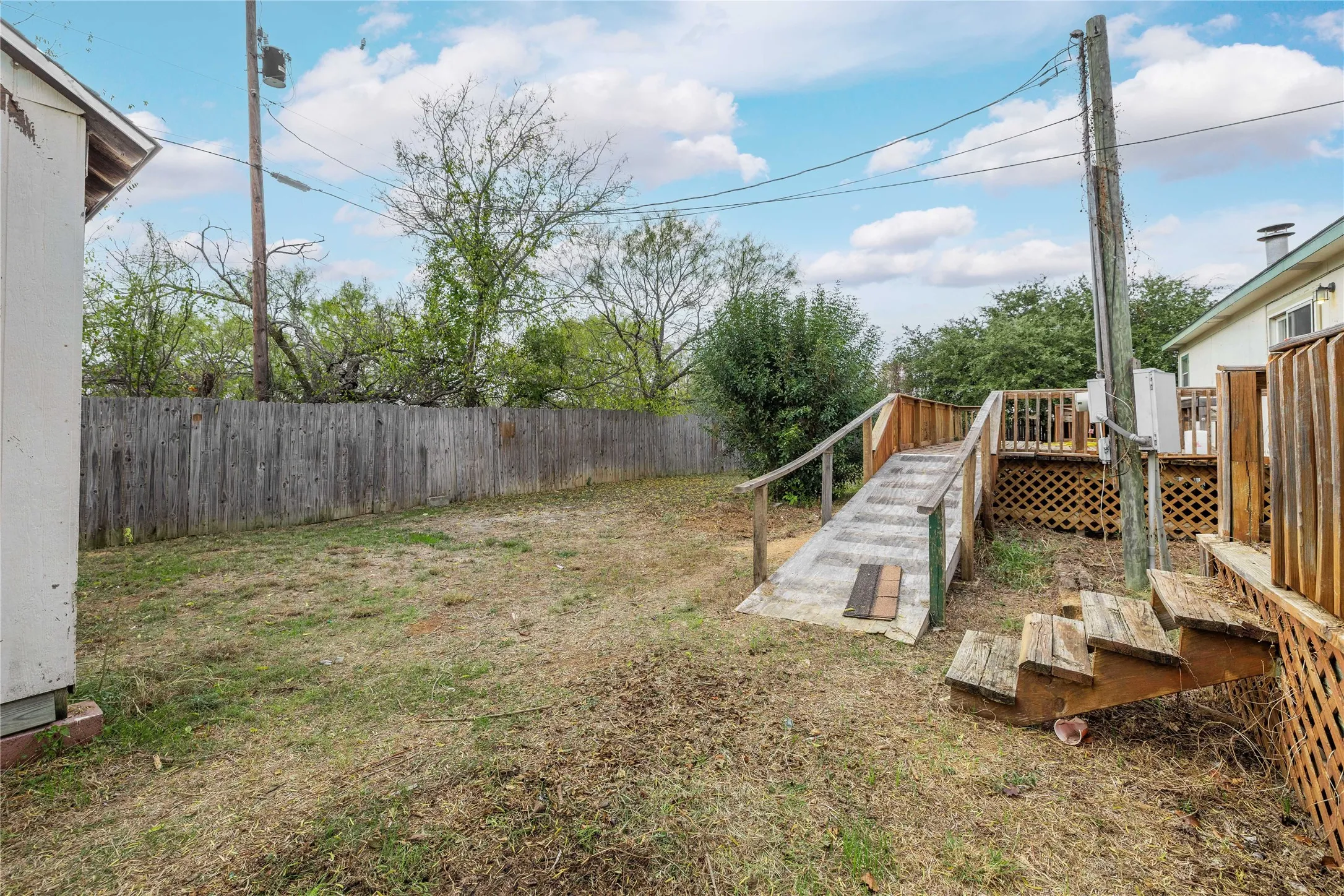 Fenced backyard featuring a deck