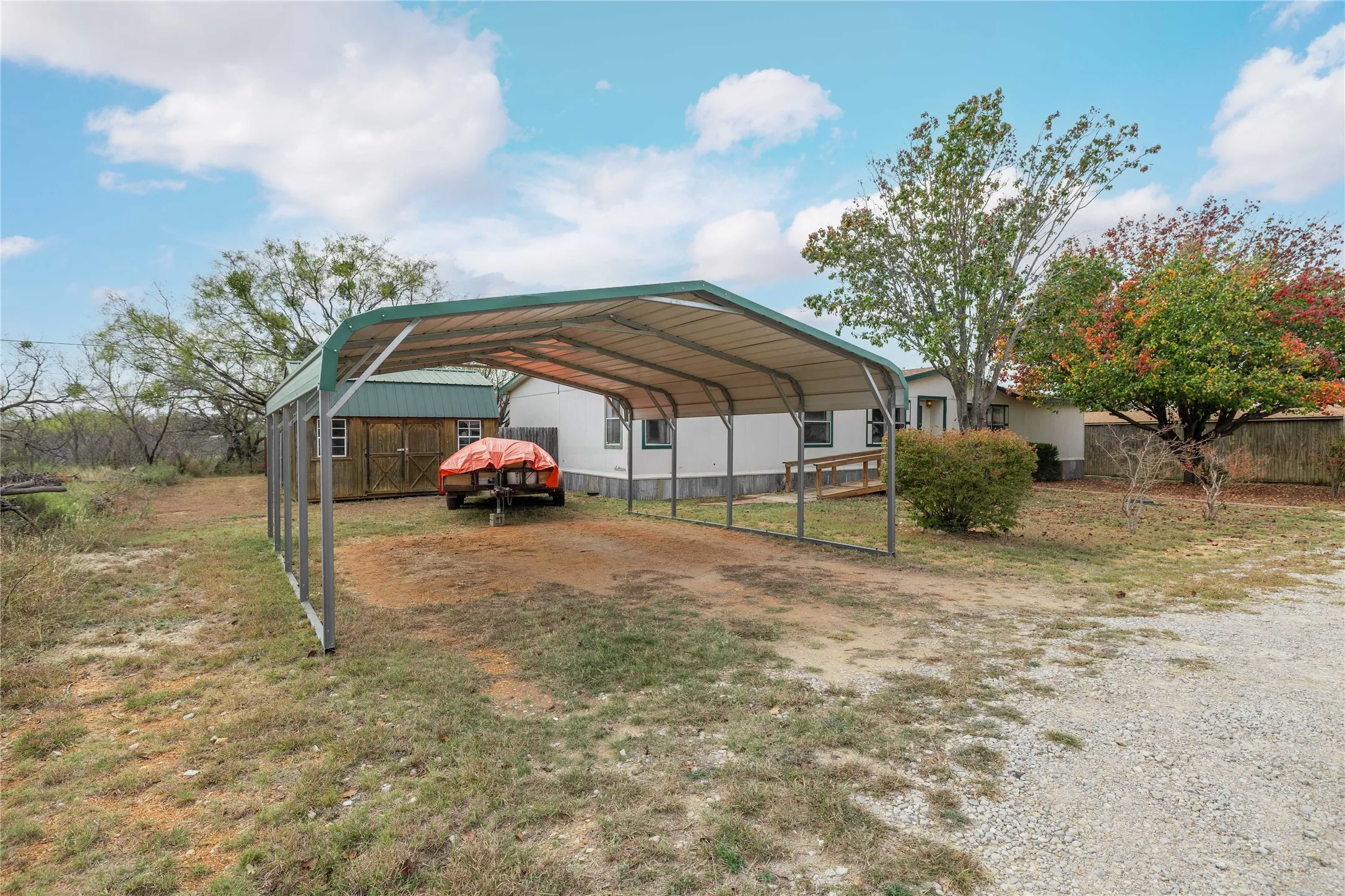 View of parking featuring a detached carport and driveway
