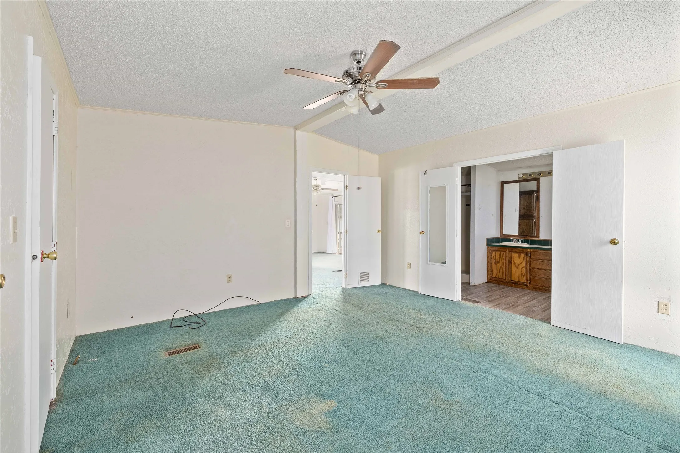 Unfurnished bedroom featuring a textured ceiling, carpet floors, and ceiling fan