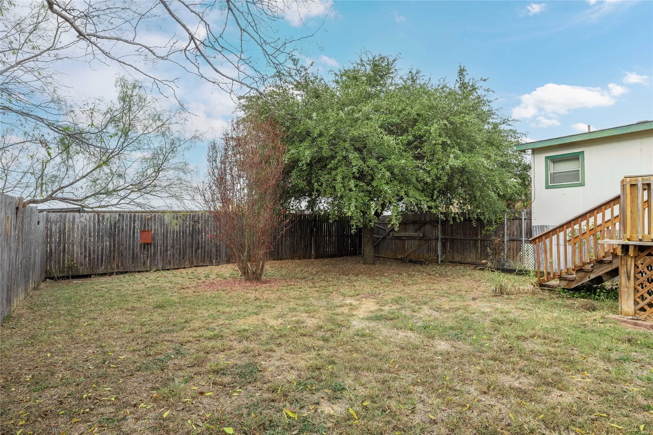 Fenced backyard featuring stairway