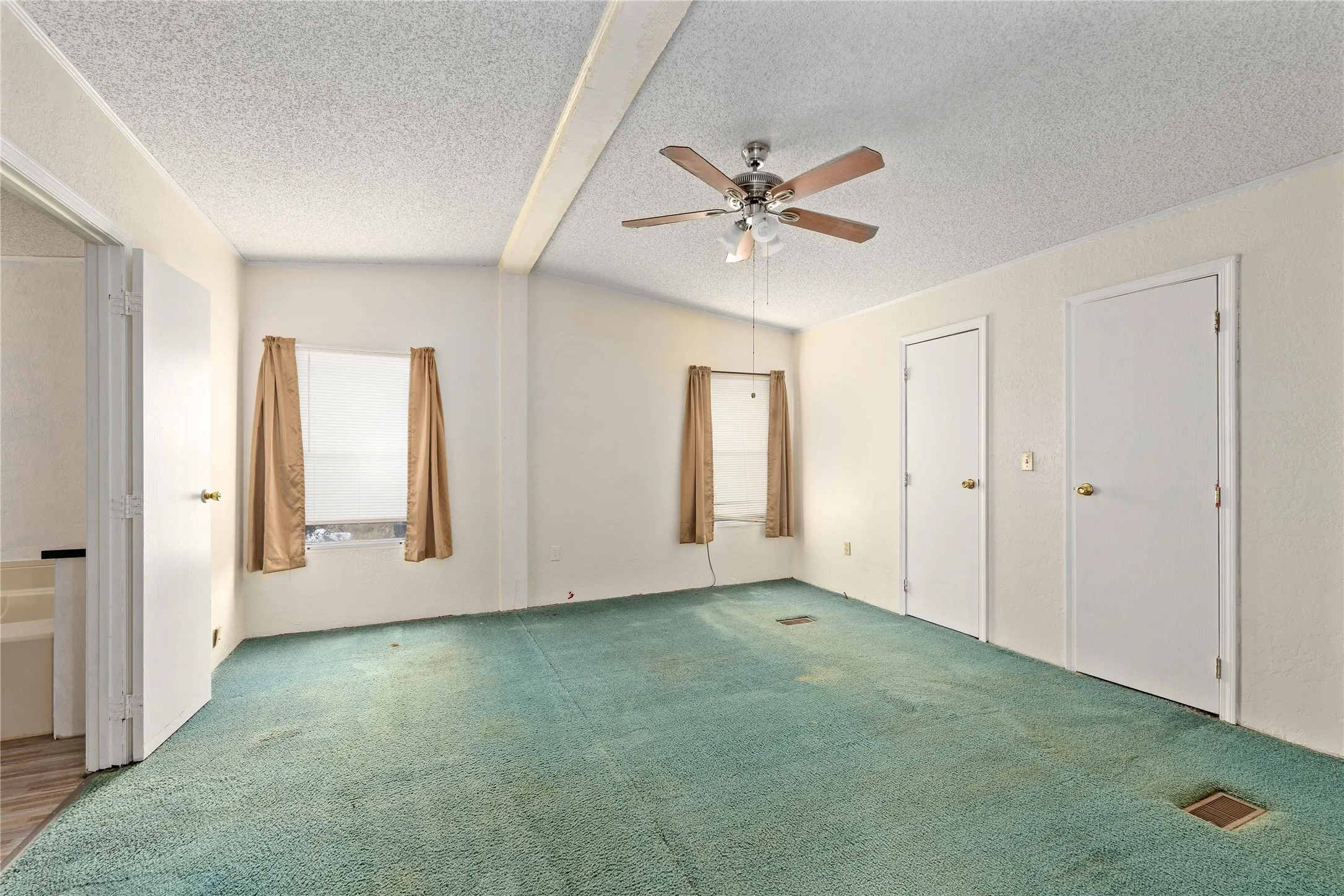 Unfurnished bedroom featuring carpet floors, a ceiling fan, a textured ceiling, and vaulted ceiling