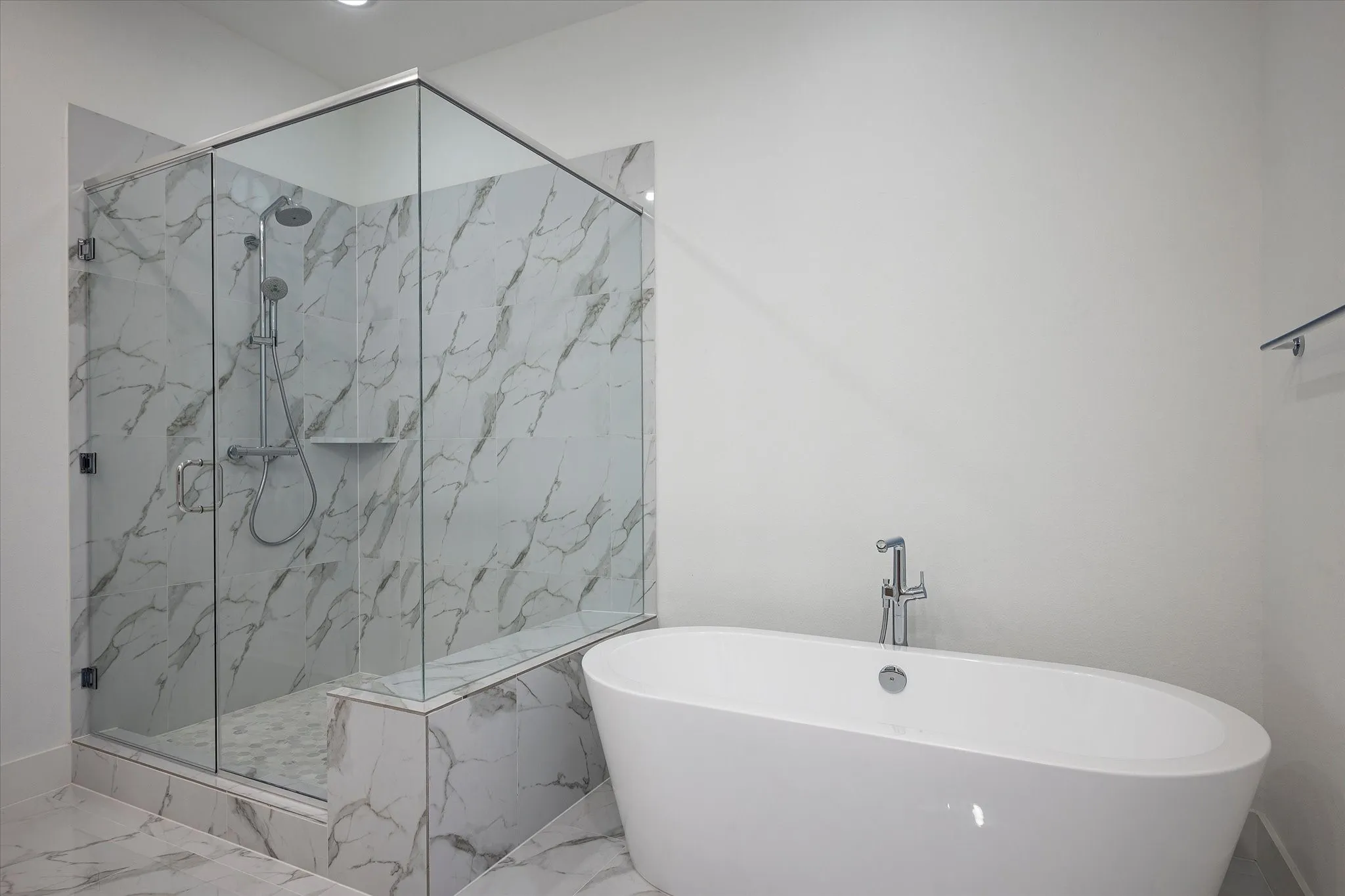 Full bath featuring marble tiled flooring, a freestanding bath, and a marble finish shower