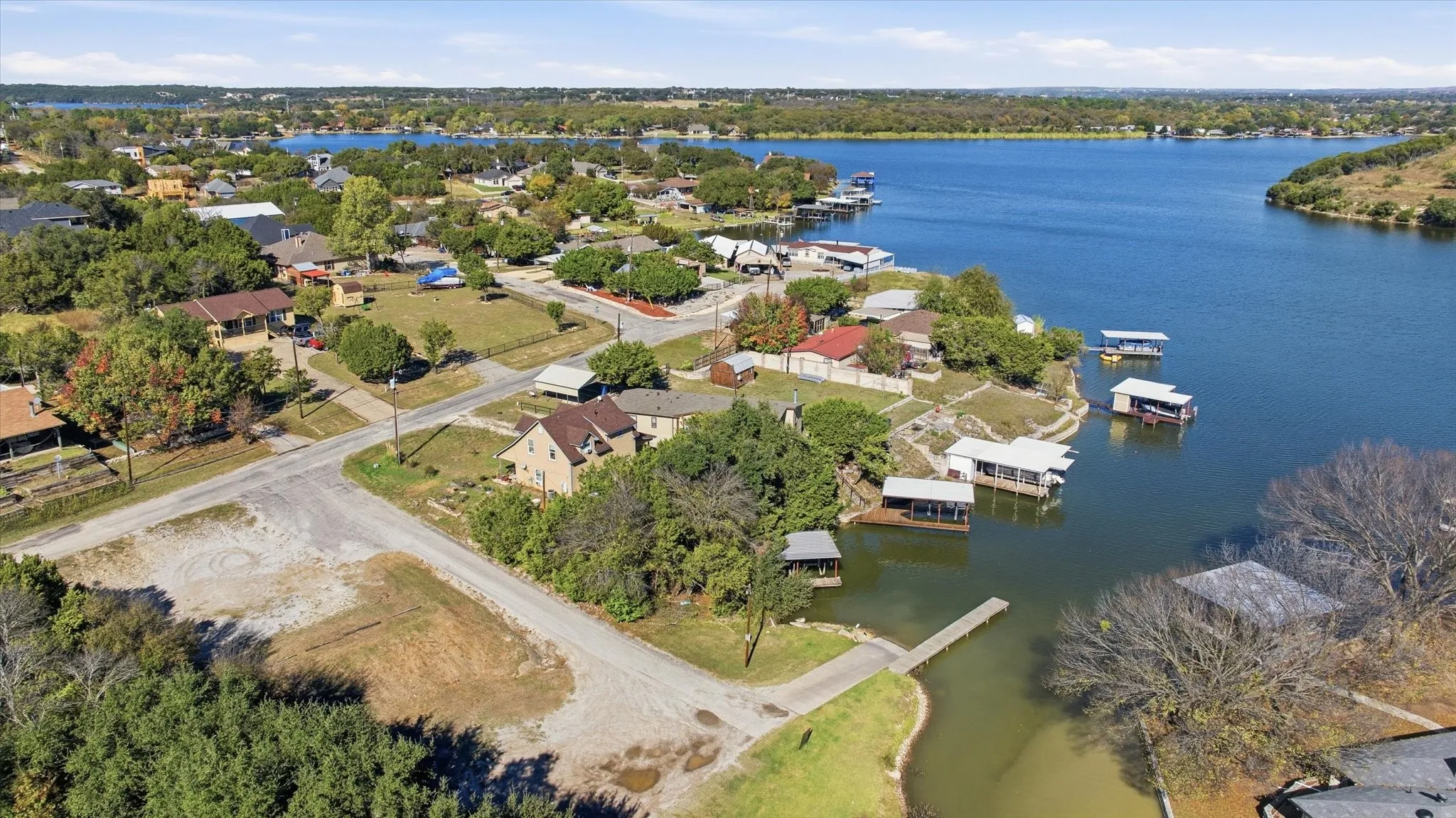 Aerial view of property's location featuring a nearby body of water and nearby suburban area
