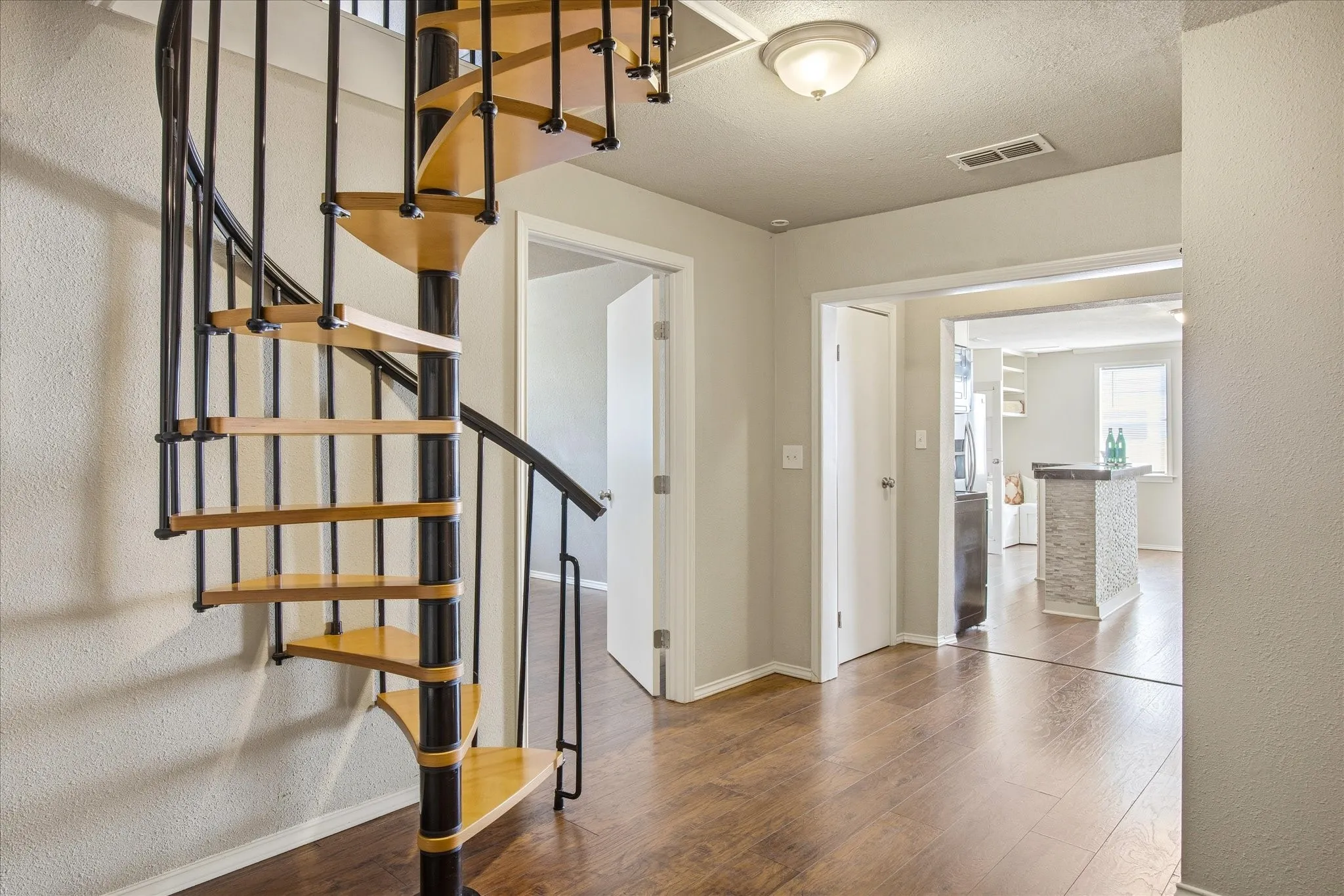 Stairway featuring a textured wall, wood finished floors and a textured ceiling