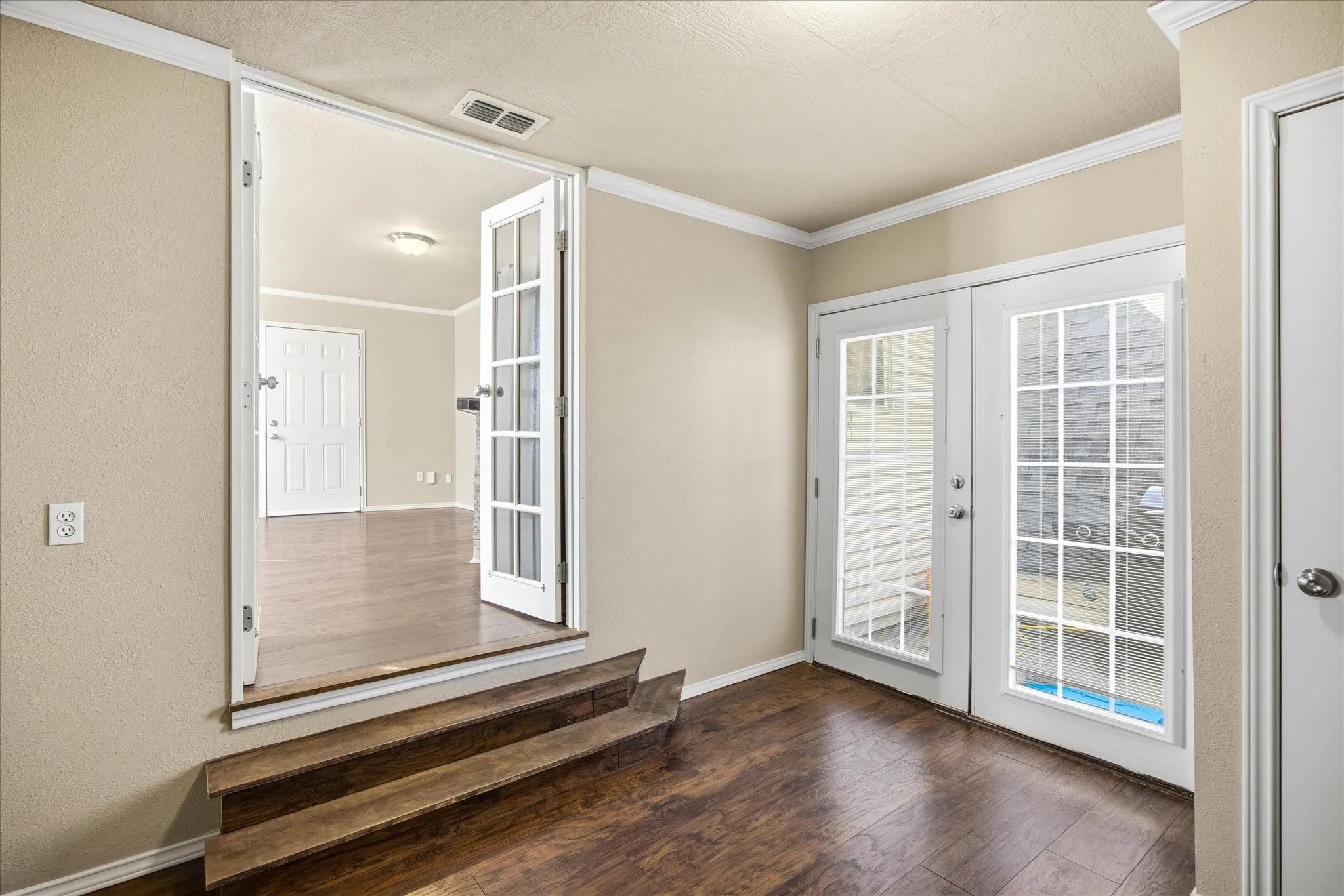 Doorway with french doors, ornamental molding and hardwood / wood-style floors