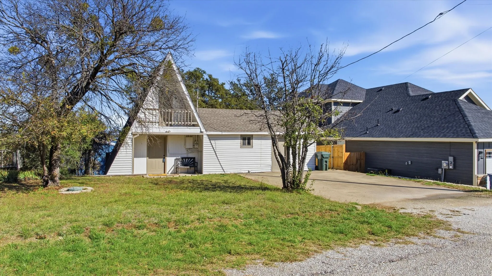 View of property exterior featuring a shingled roof, a balcony and driveway