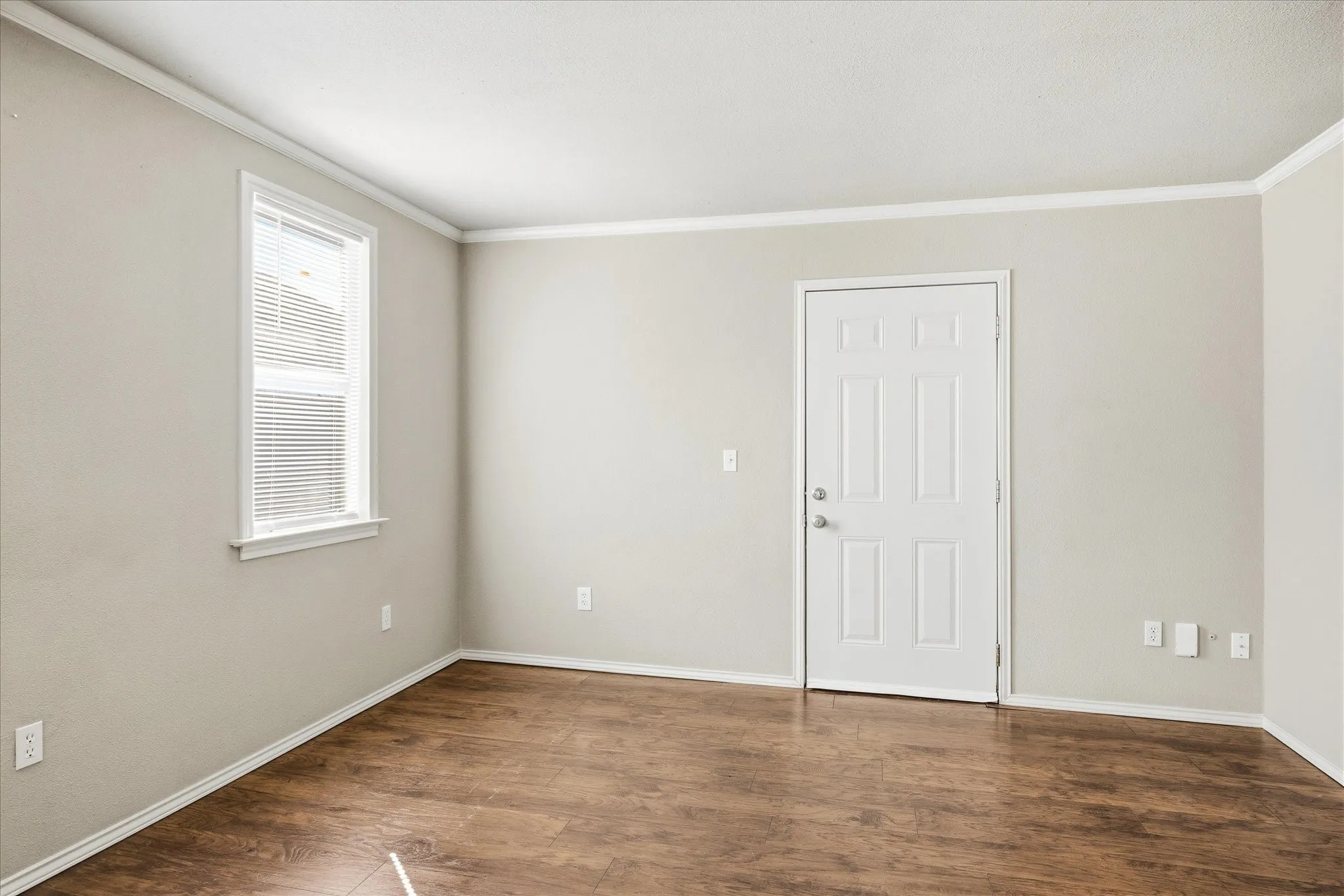 Unfurnished room with crown molding and dark wood-type flooring