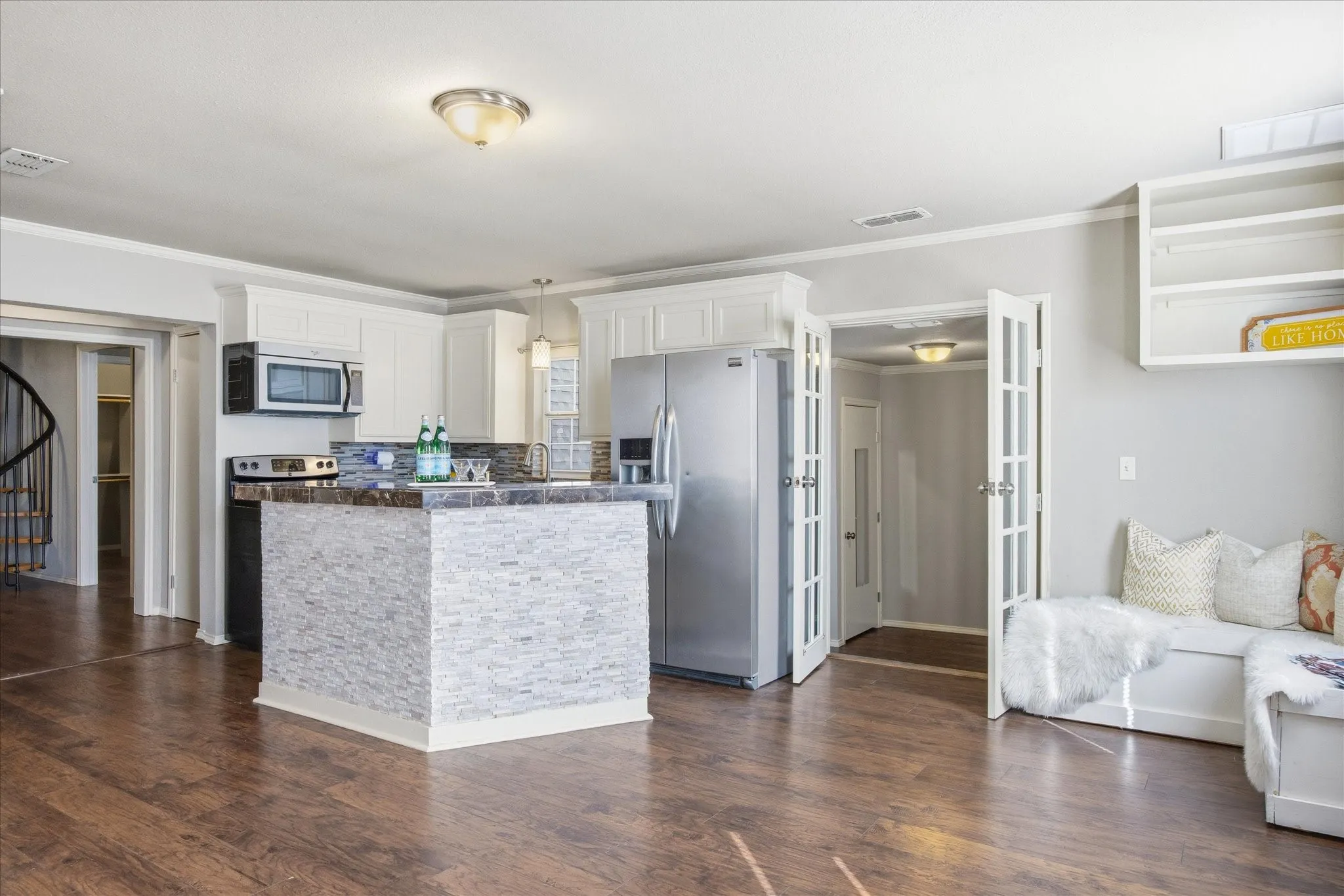 Kitchen featuring a center island, appliances with stainless steel finishes, hanging light fixtures, white cabinets, and dark wood-style flooring