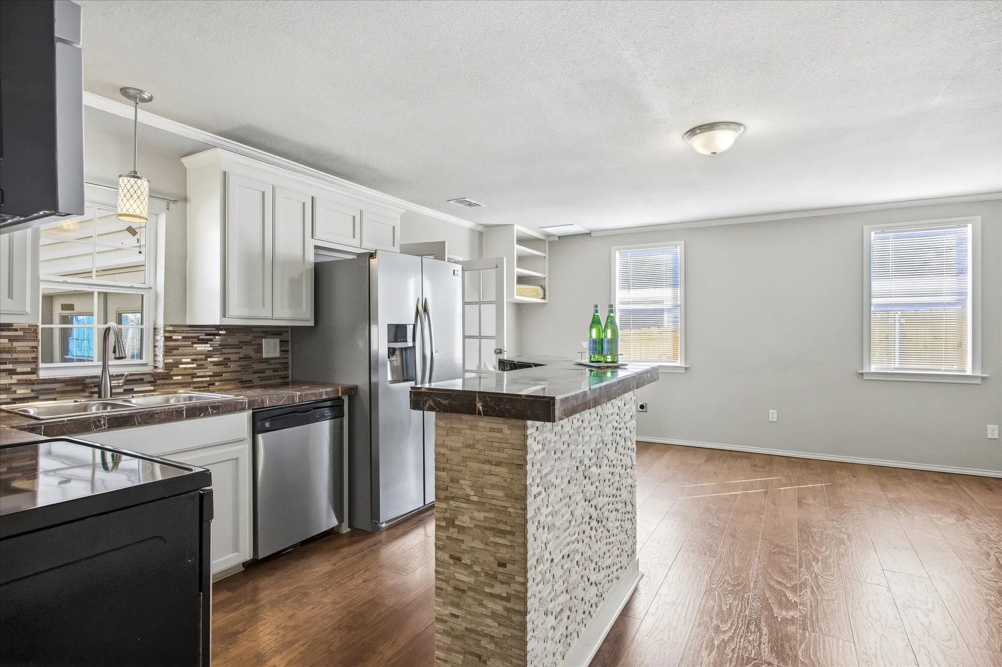 Kitchen featuring tile counters, white cabinets, stainless steel dishwasher, decorative backsplash and black electric range oven