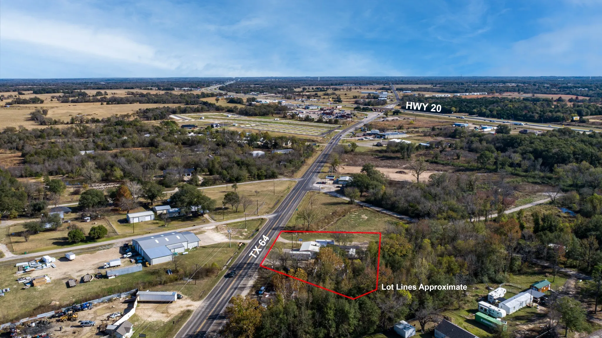 Aerial view of property and surrounding area with property parcel outlined and a tree filled landscape