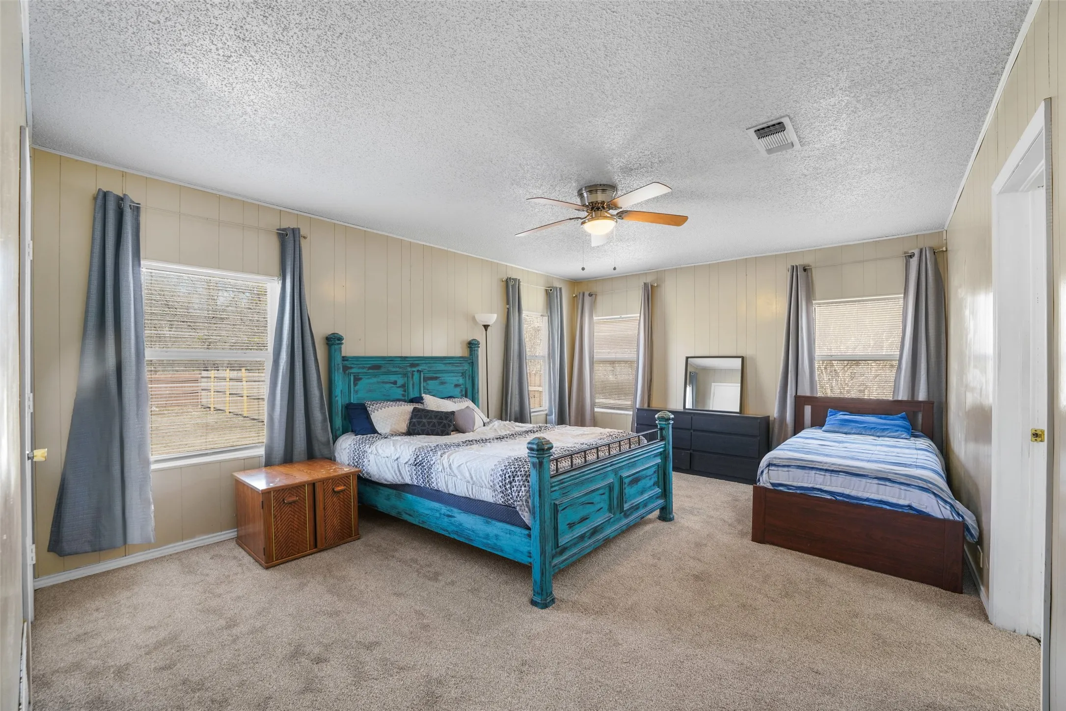 Bedroom featuring carpet floors, a ceiling fan, and a textured ceiling