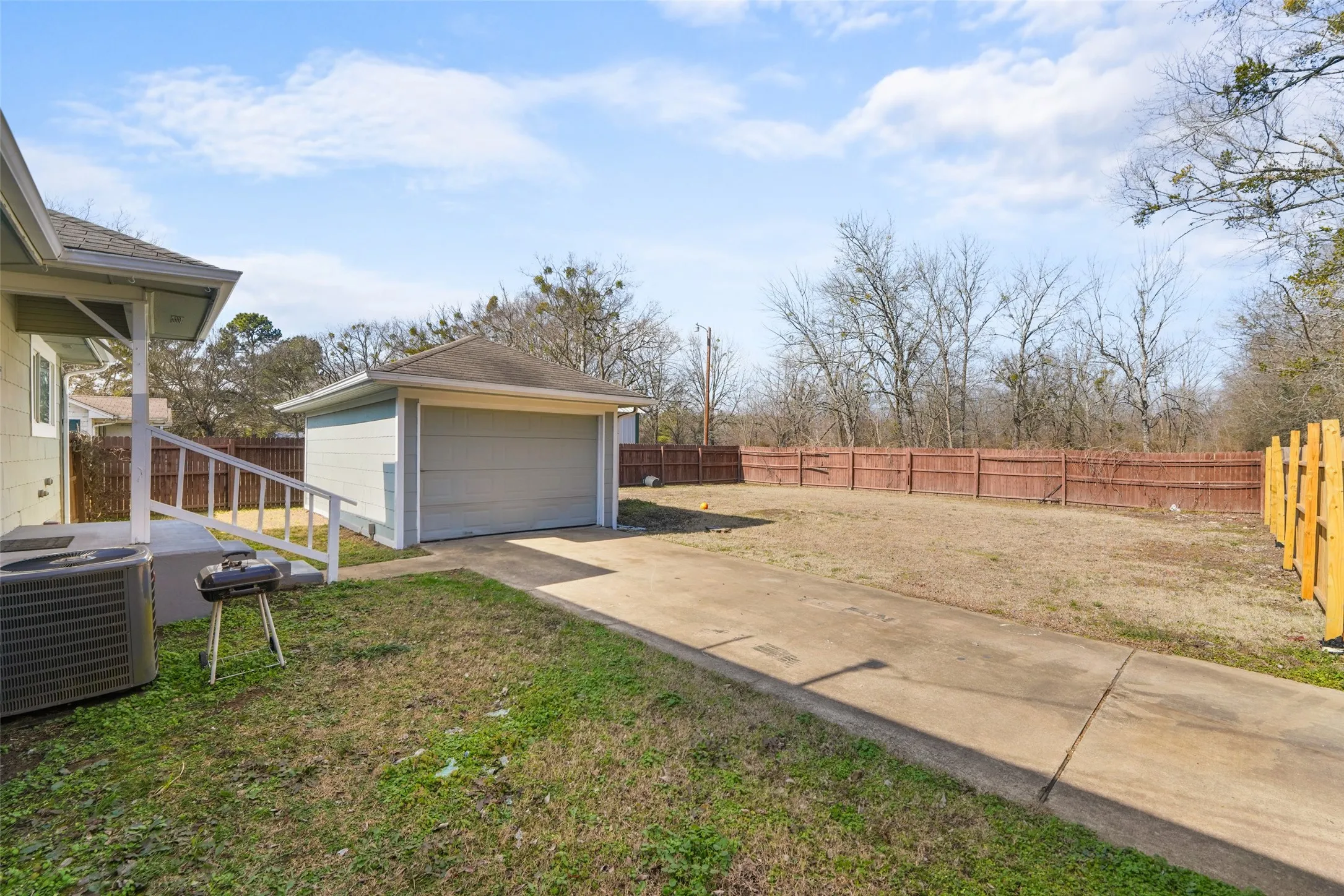 Fenced backyard featuring an outdoor structure and a garage
