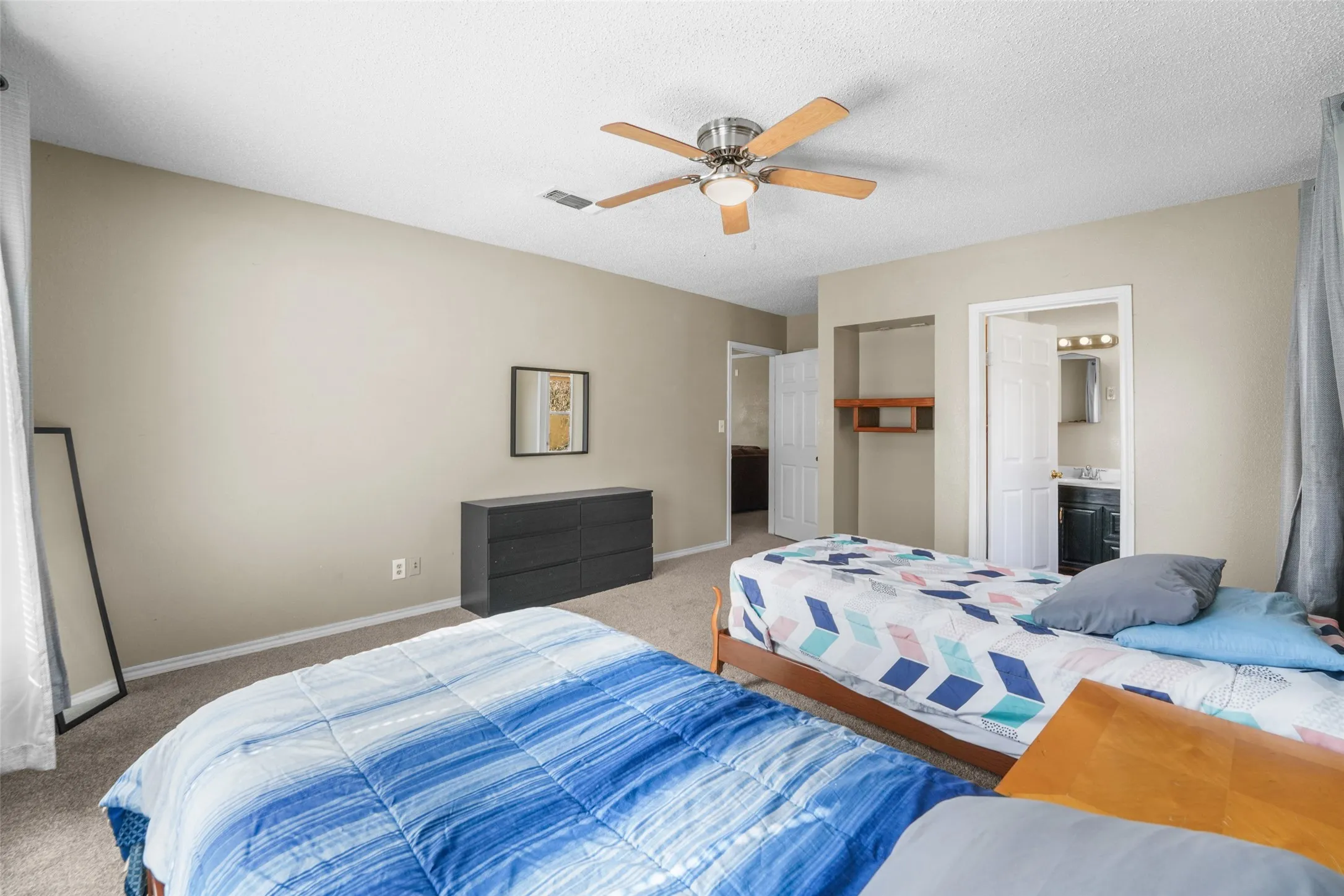 Bedroom featuring carpet flooring, a ceiling fan, and a textured ceiling