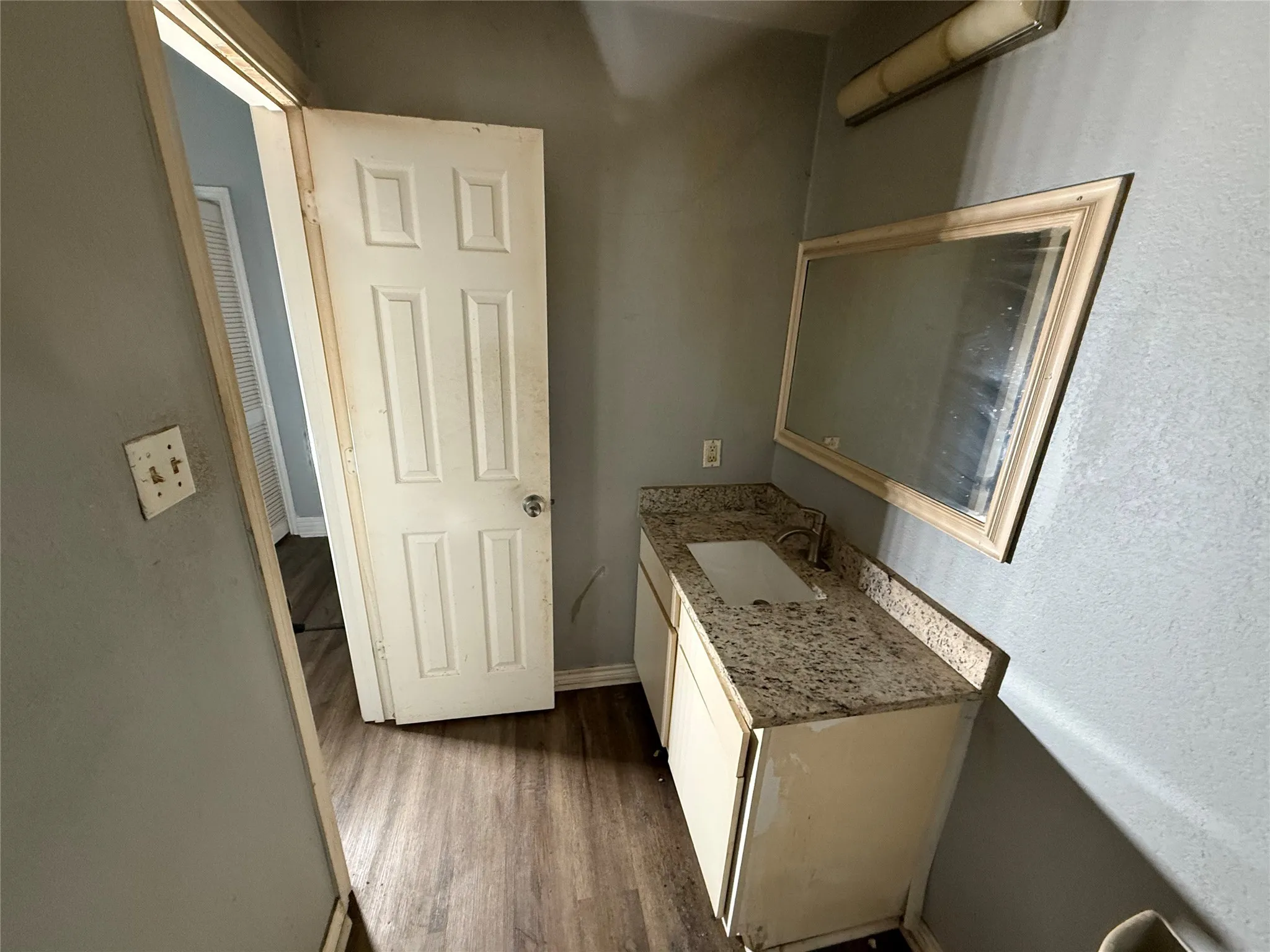 Half bath with vanity and dark wood-style flooring