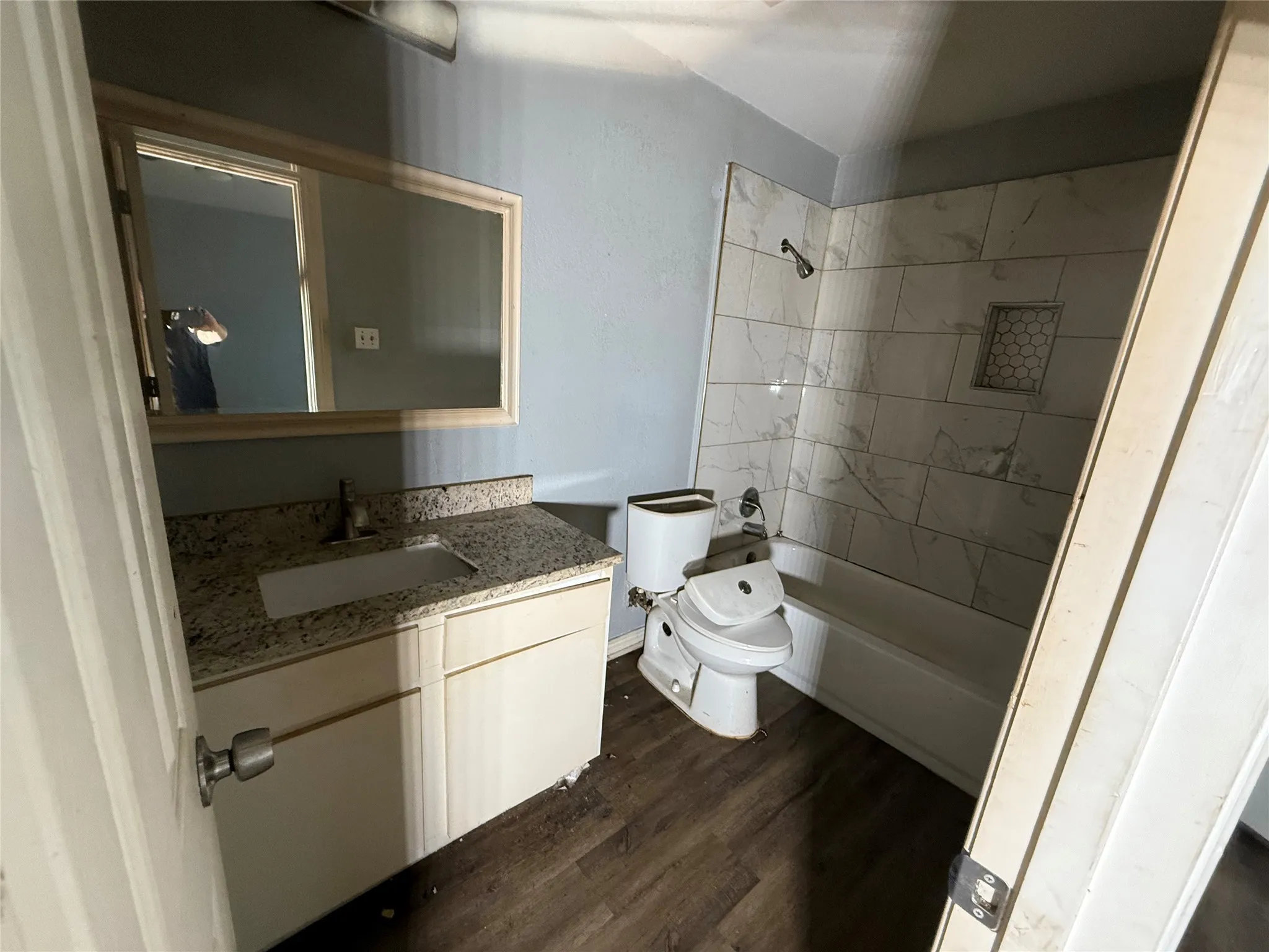 Full bathroom with vanity, shower / bath combination, and dark wood-style flooring