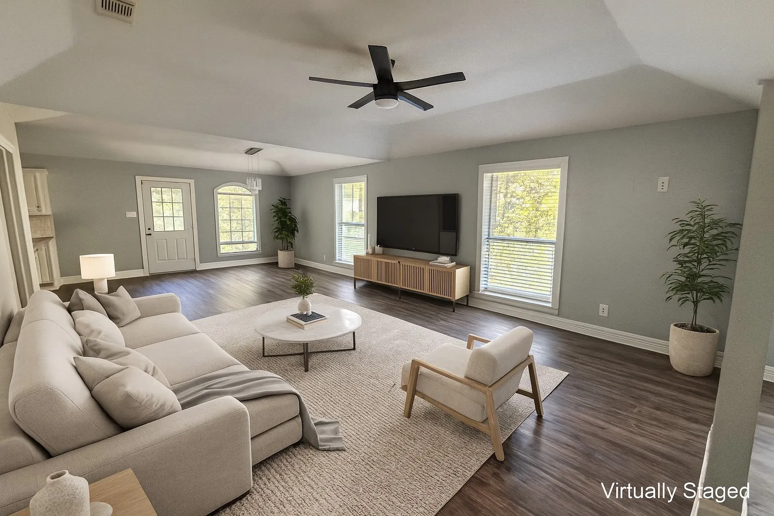Living area featuring dark wood-style flooring, a ceiling fan, and vaulted ceiling