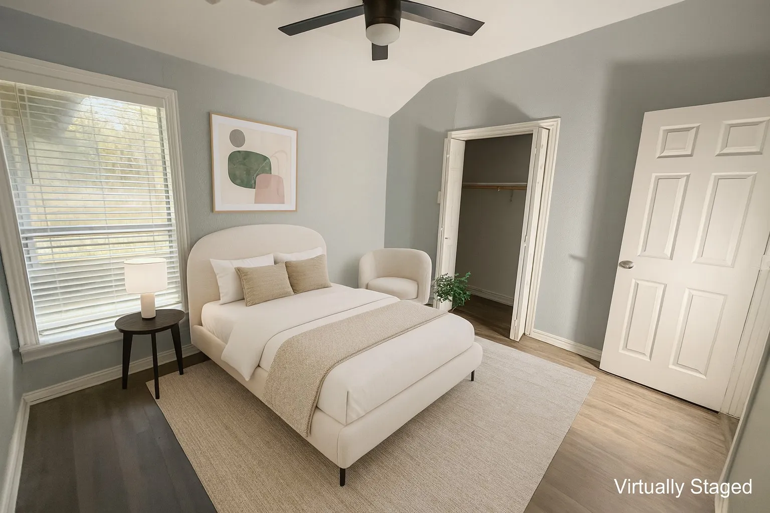 Bedroom featuring light wood-type flooring, lofted ceiling, and a ceiling fan