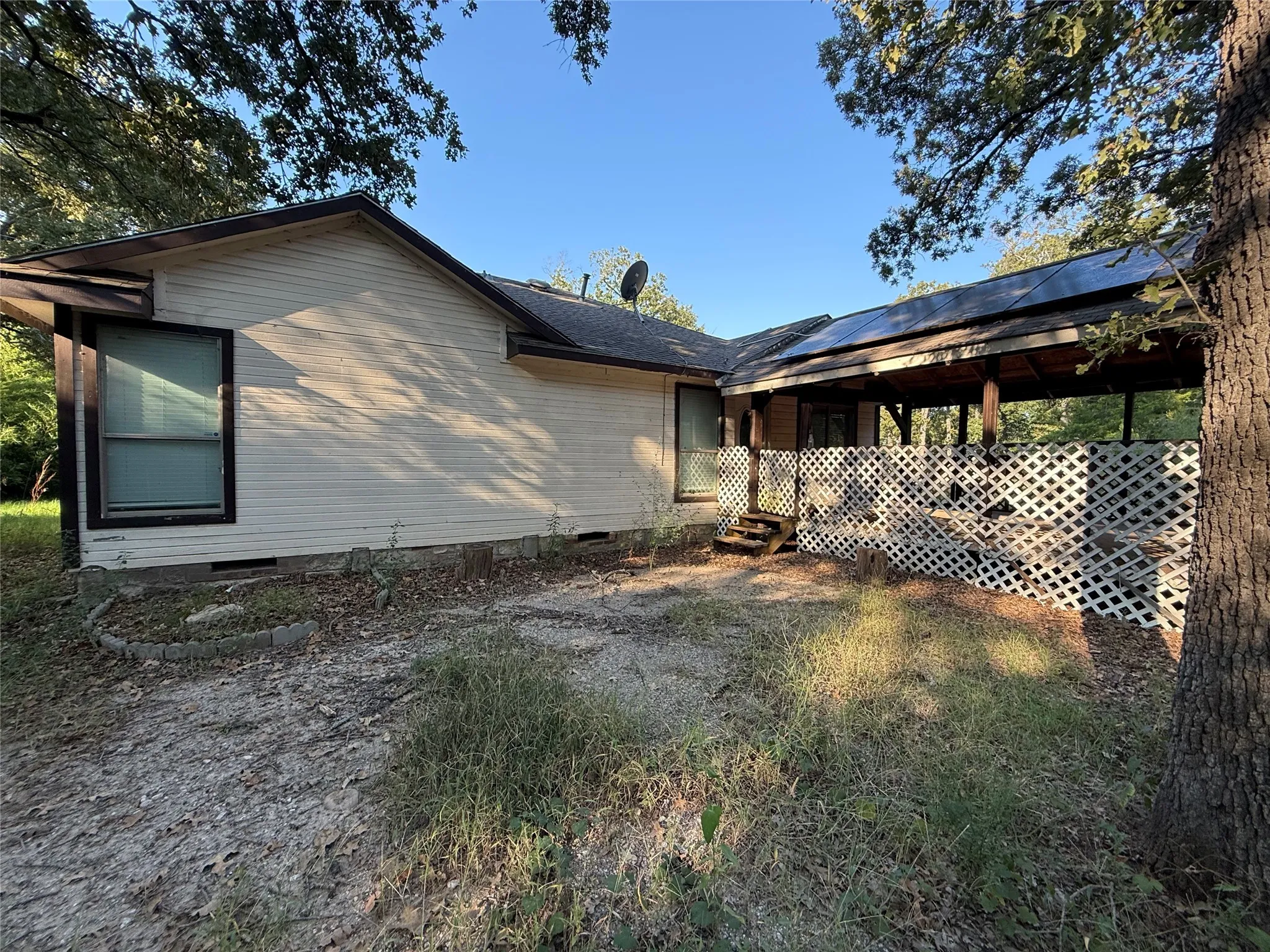 Rear view of house featuring crawl space and solar panels