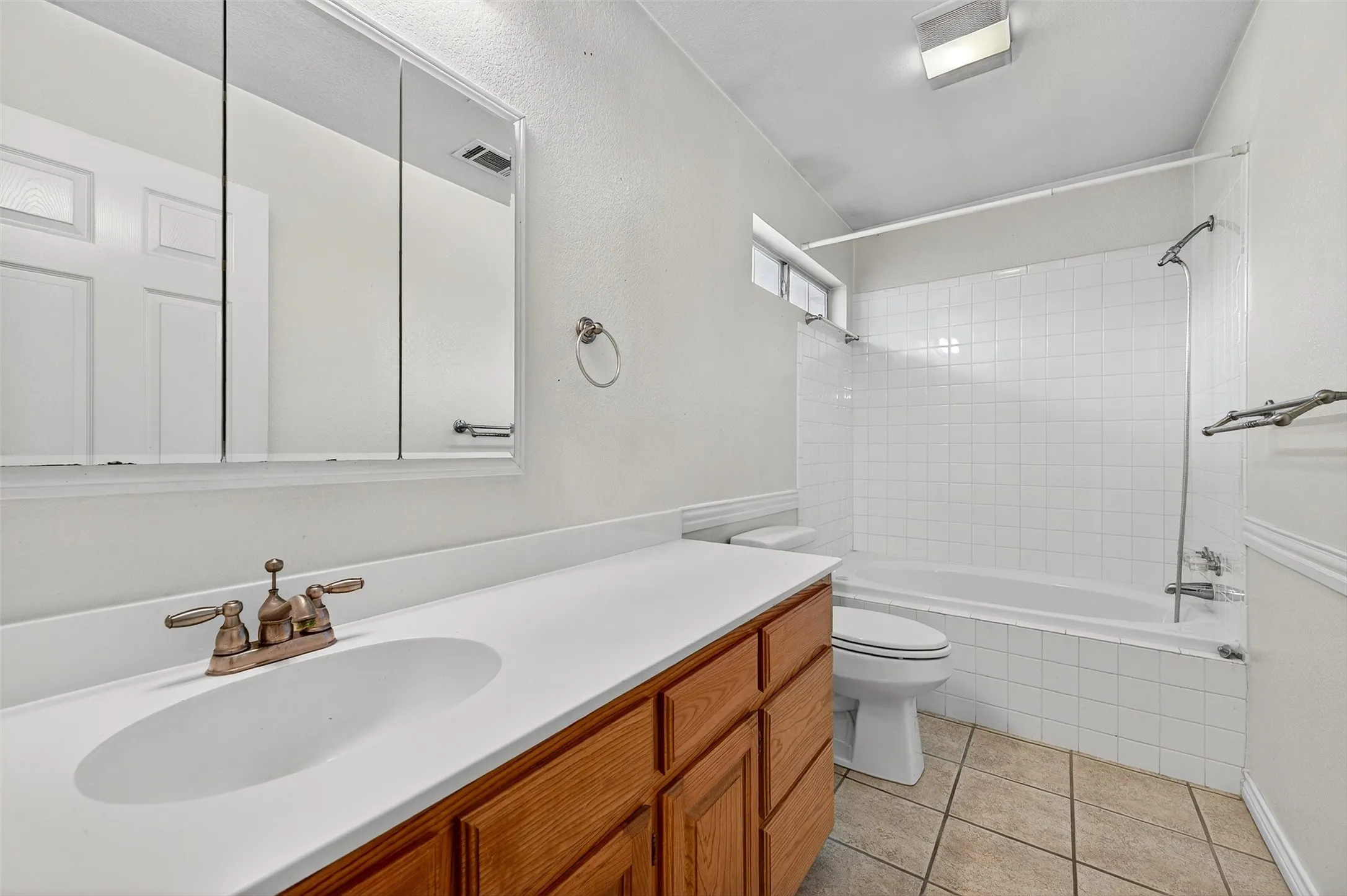 Full bathroom featuring vanity, tiled shower / bath, and light tile patterned floors