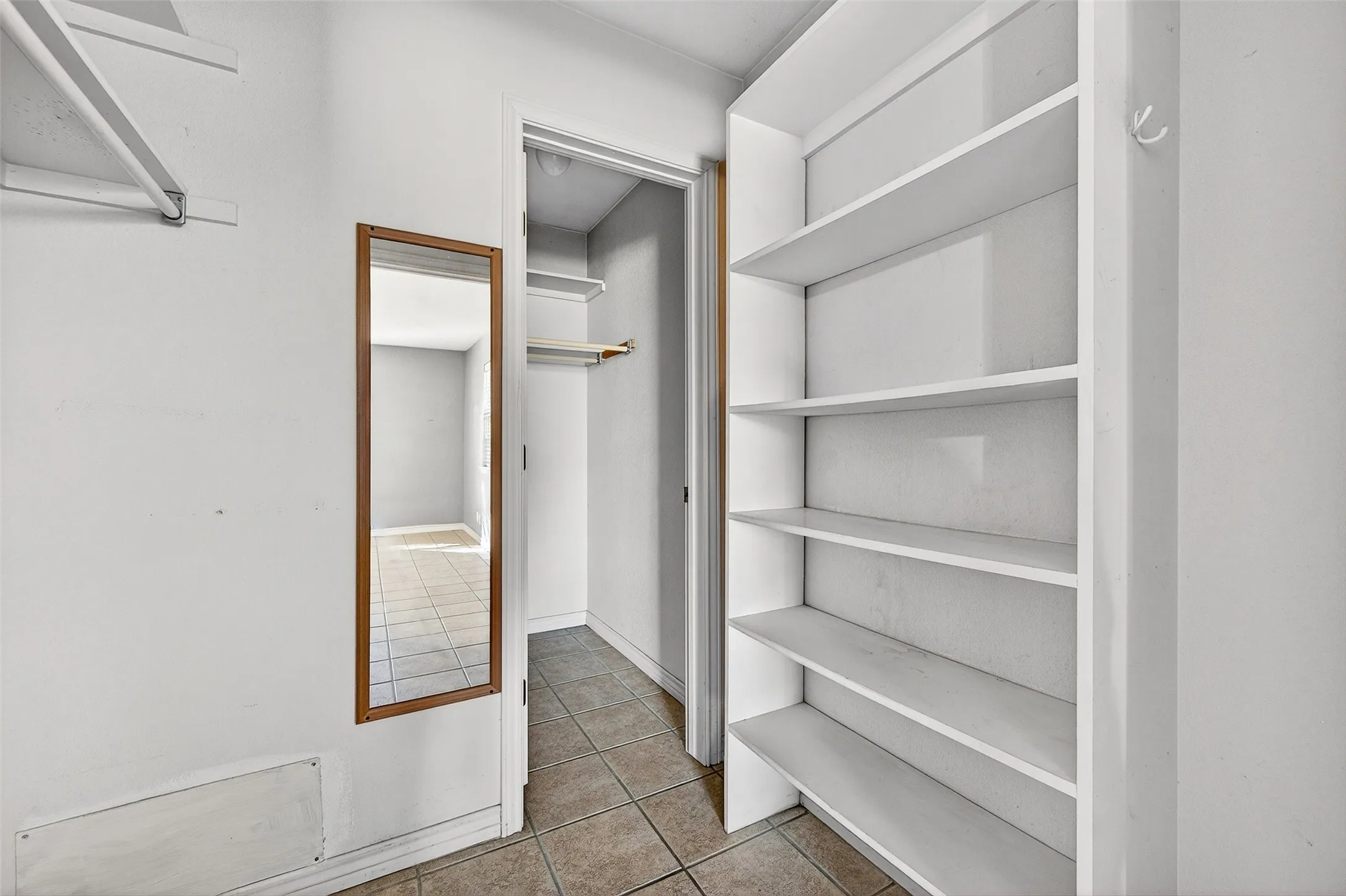 Walk in closet with light tile patterned floors