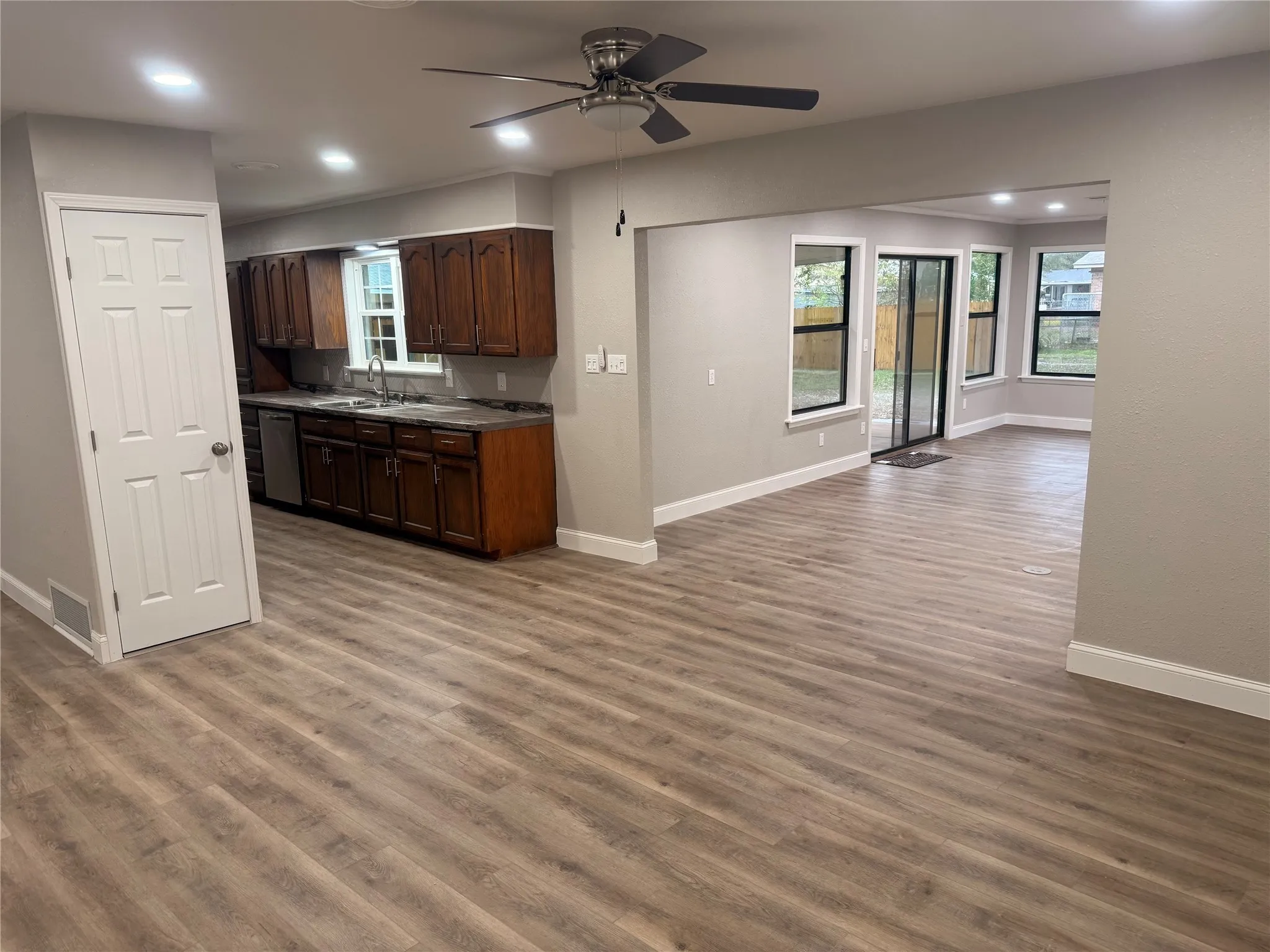 Kitchen with dark countertops, open floor plan, recessed lighting, a ceiling fan, and dark brown cabinetry