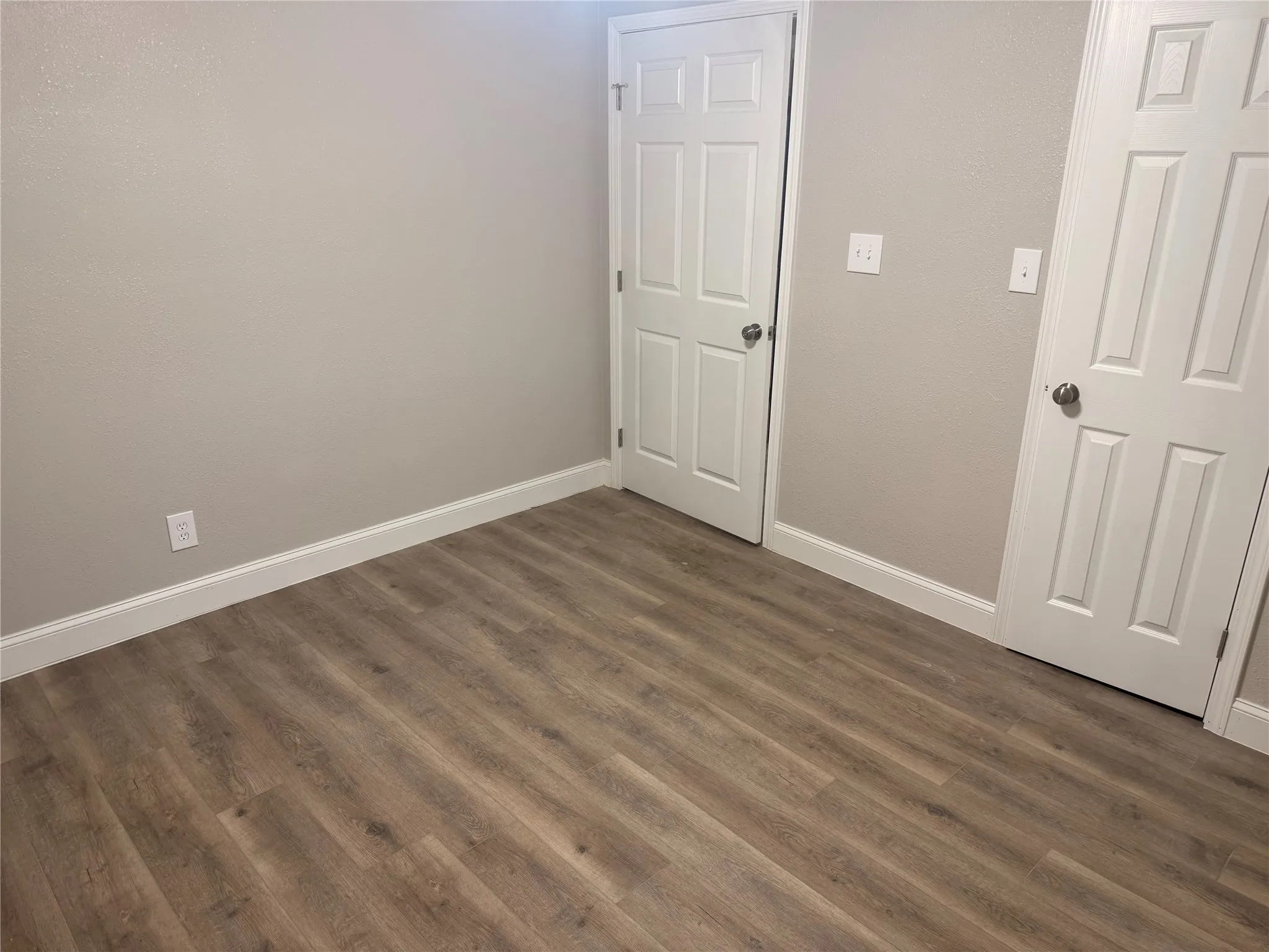 Unfurnished bedroom featuring dark wood-style flooring