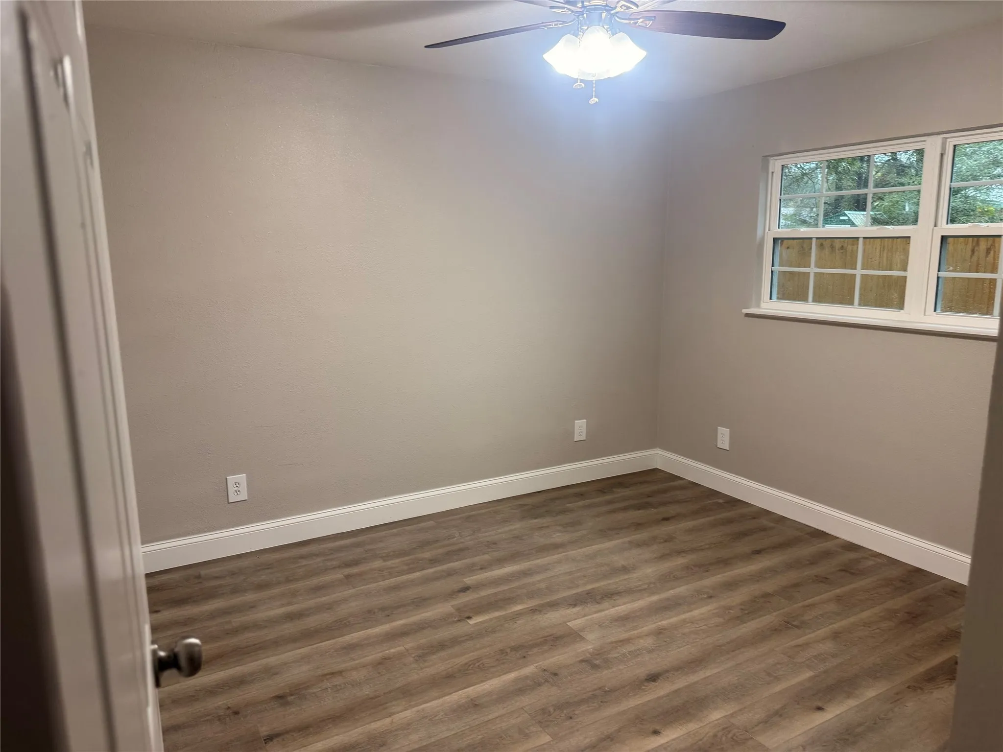 Spare room featuring dark wood-style floors and ceiling fan