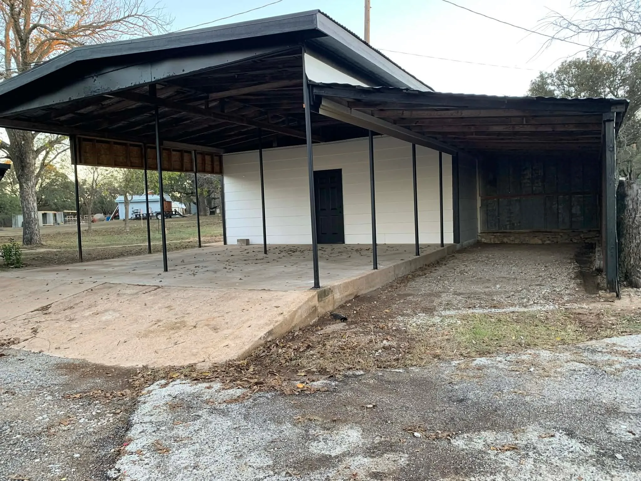 View of outbuilding with a carport and driveway