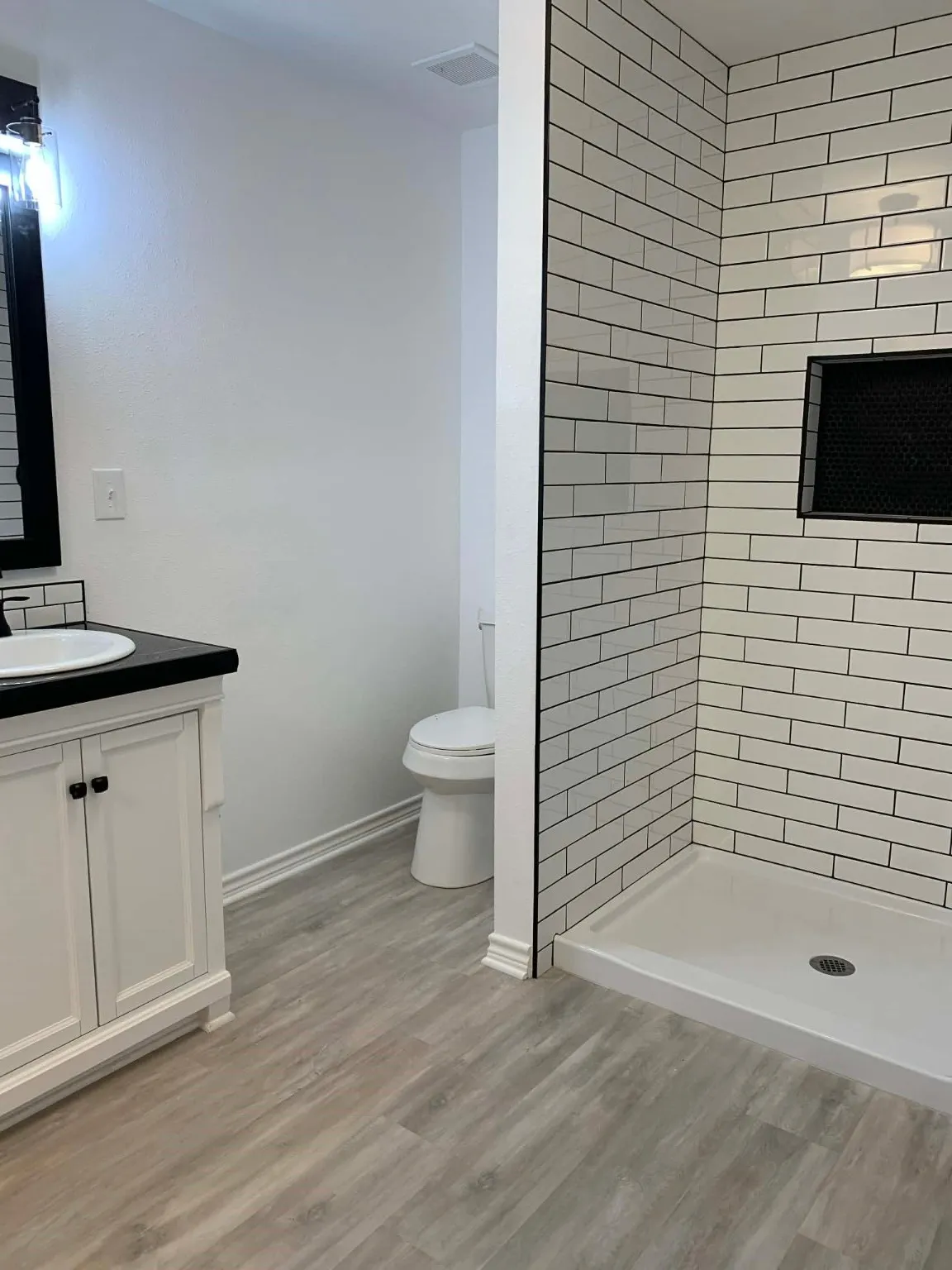 Full bath featuring vanity, a shower stall, and light wood-type flooring