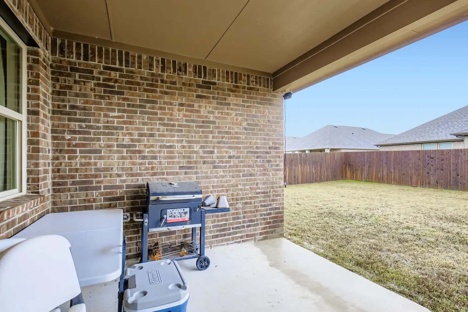 Fenced backyard featuring a patio area and grilling area