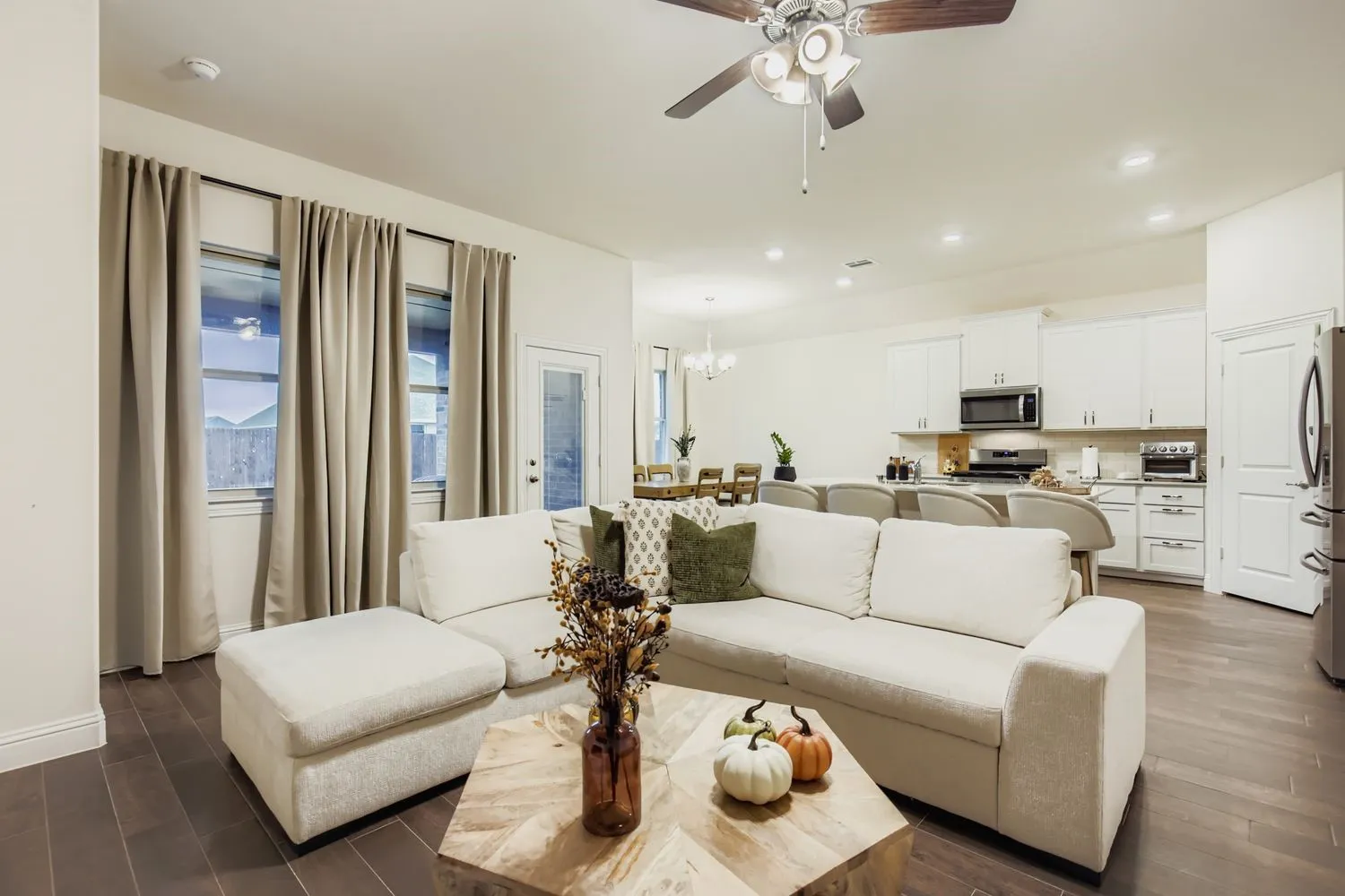 Living room featuring a chandelier, dark wood finished floors, a ceiling fan, and recessed lighting