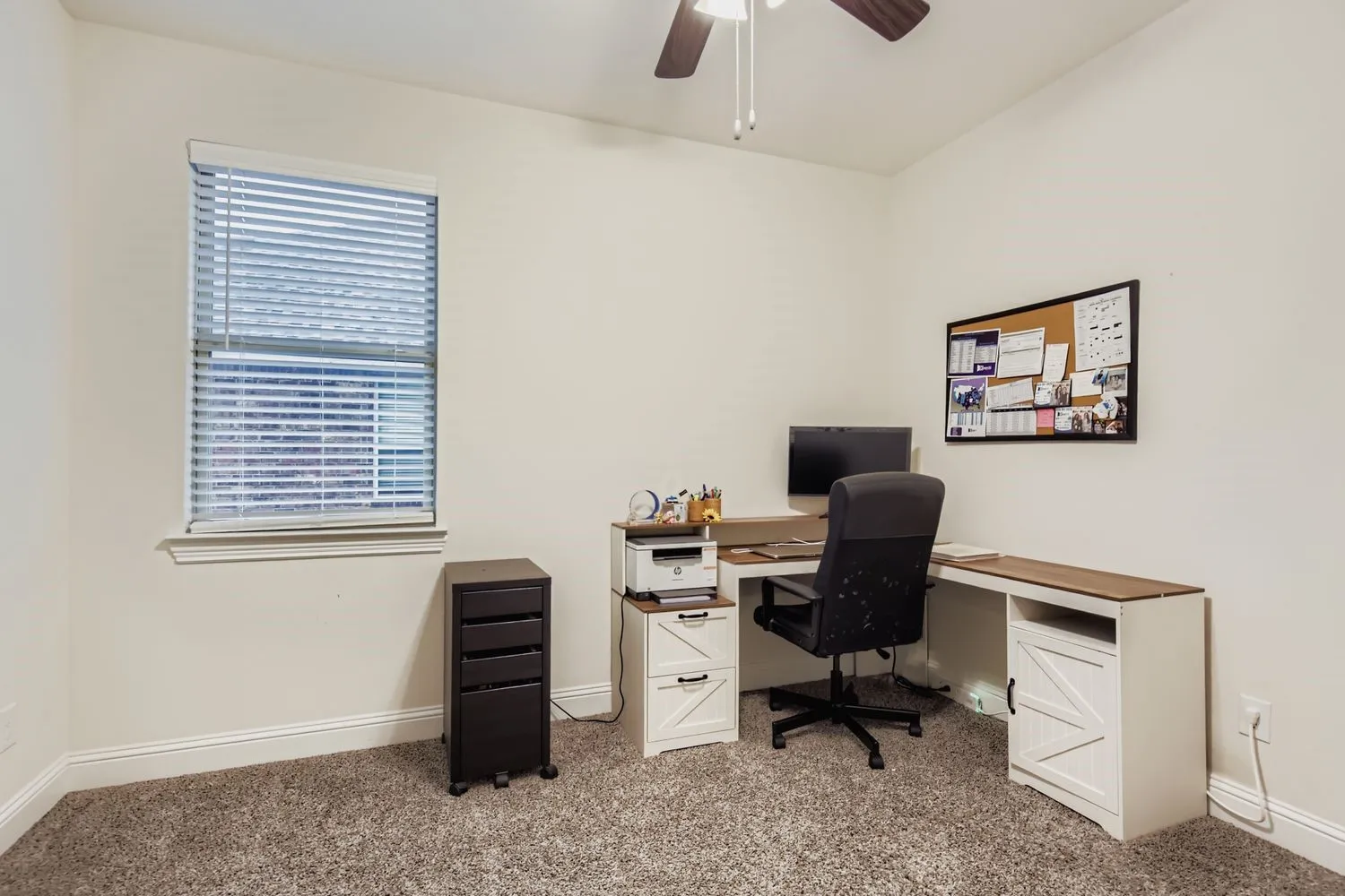 Office space with light colored carpet and a ceiling fan