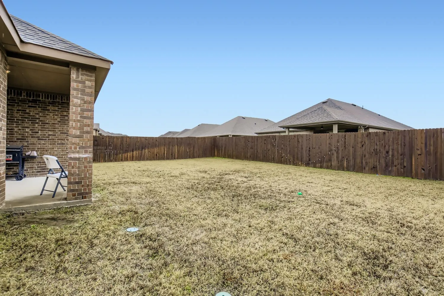 Fenced backyard with a patio