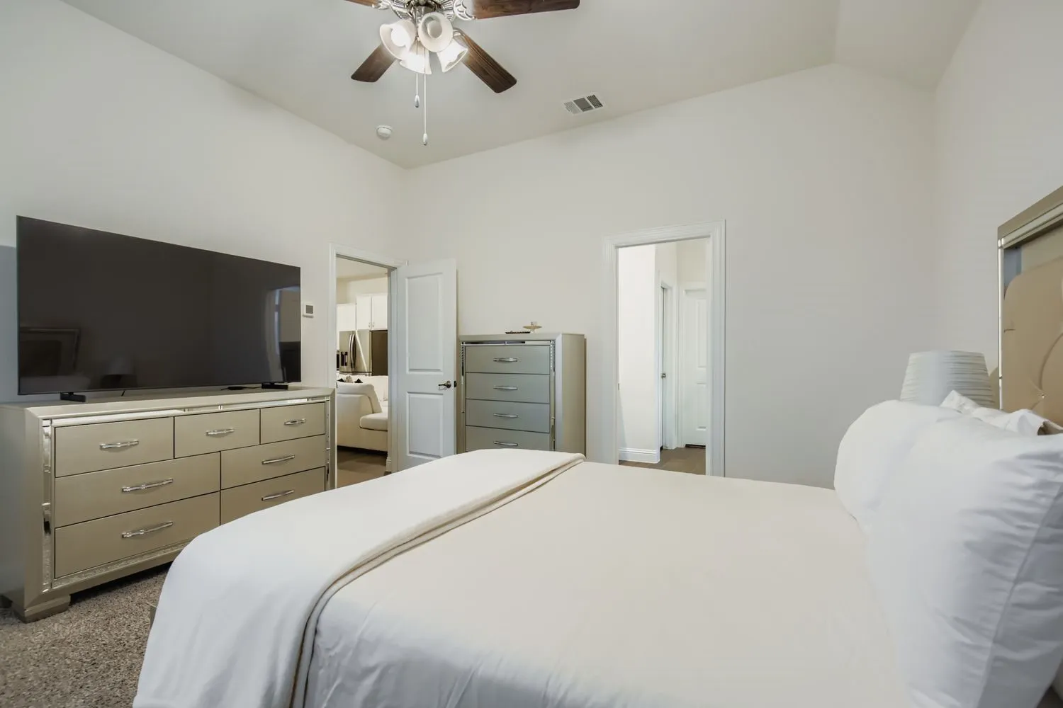 Bedroom featuring vaulted ceiling, a ceiling fan, and light colored carpet