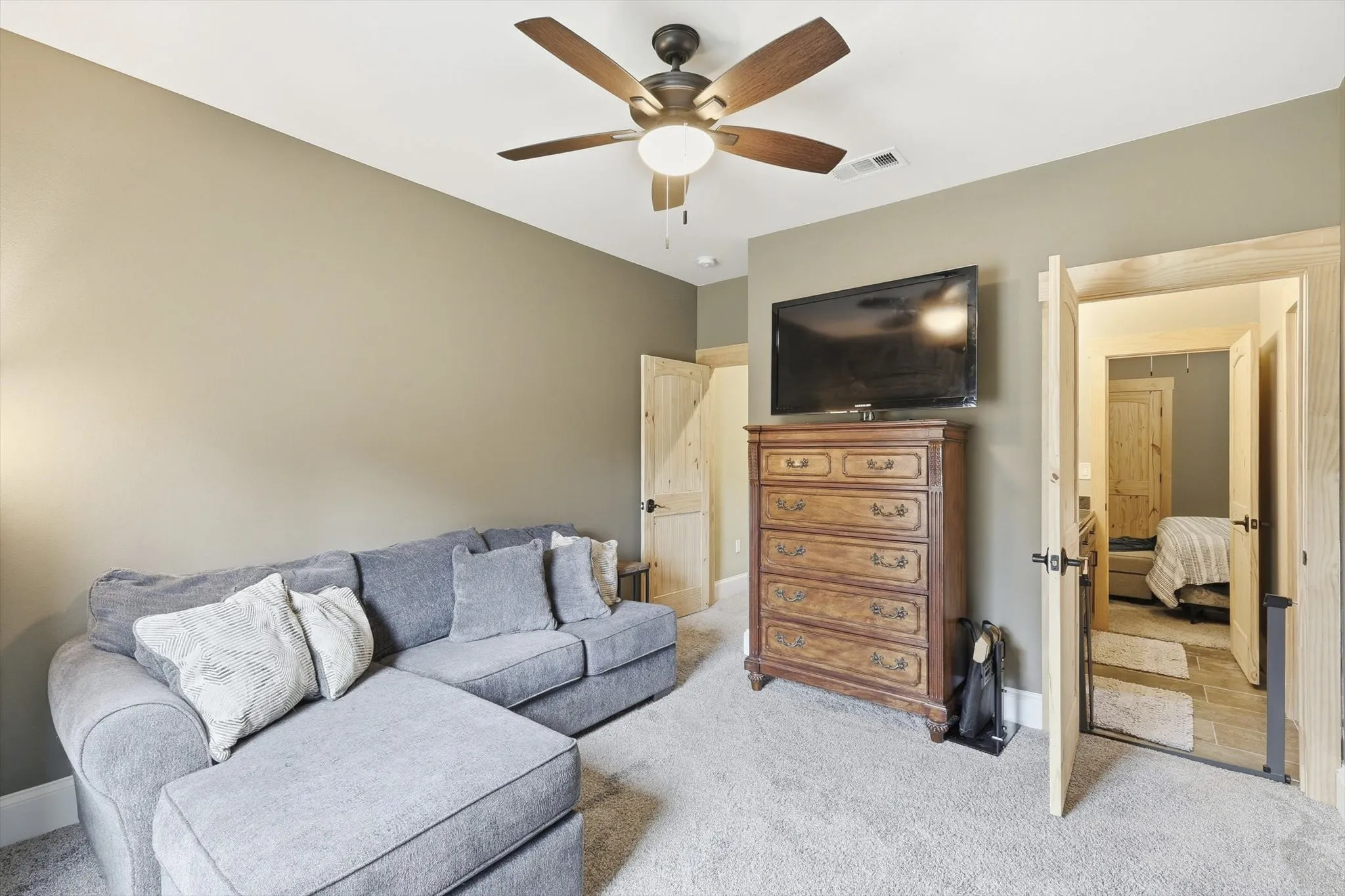 Living area with carpet floors and a ceiling fan