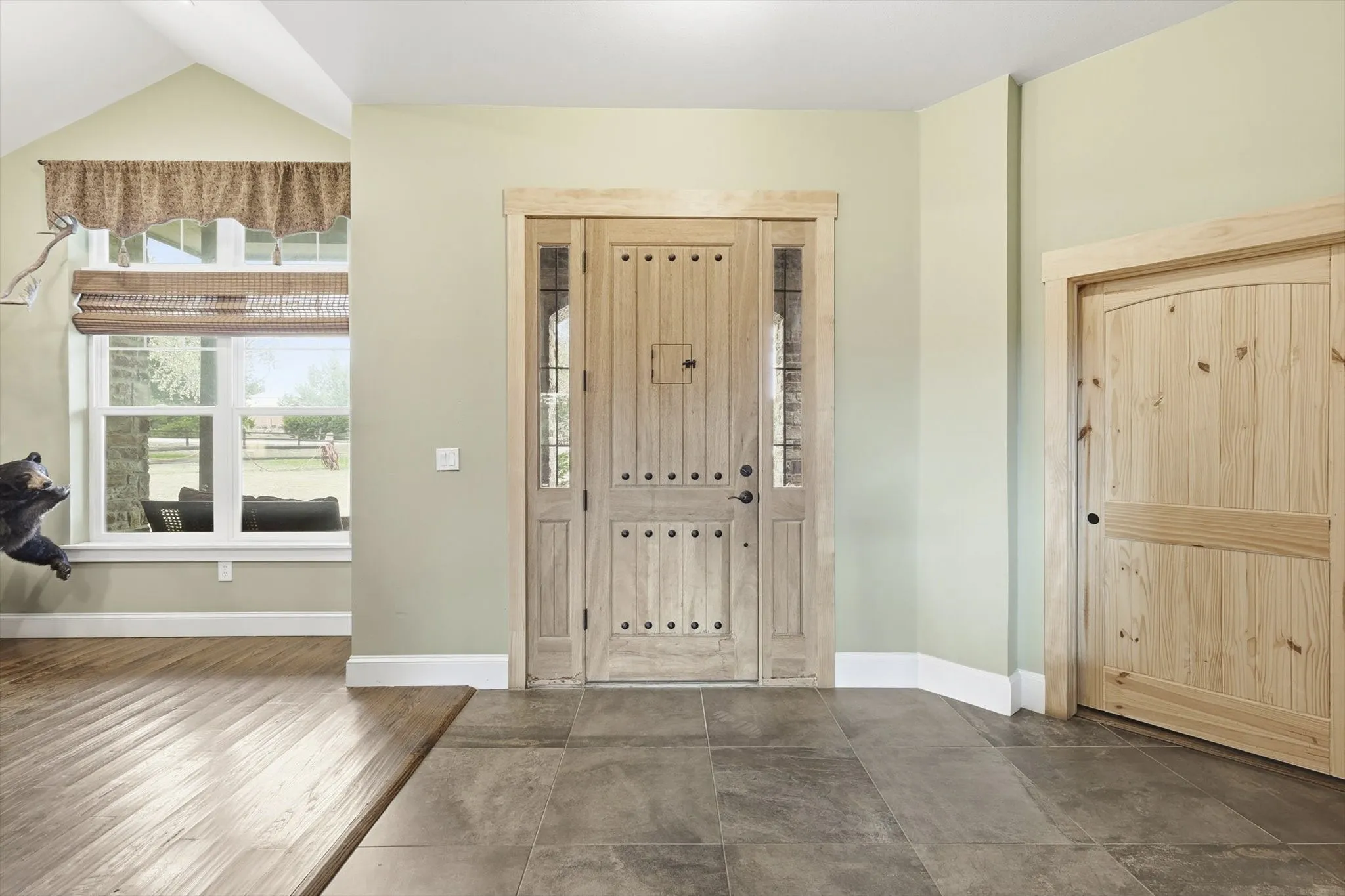 Entryway featuring baseboards and vaulted ceiling