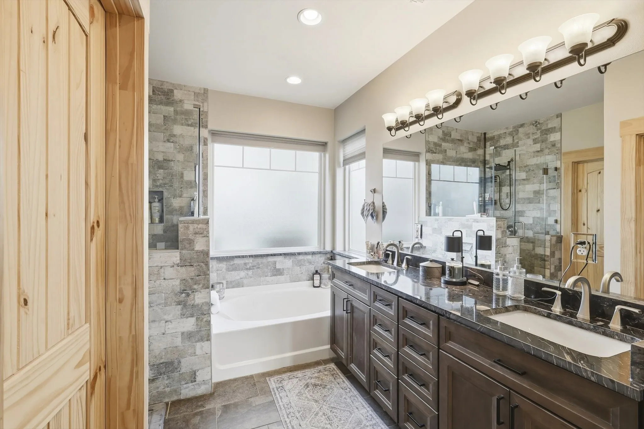 Full bathroom featuring double vanity, a garden tub, a stall shower, and recessed lighting