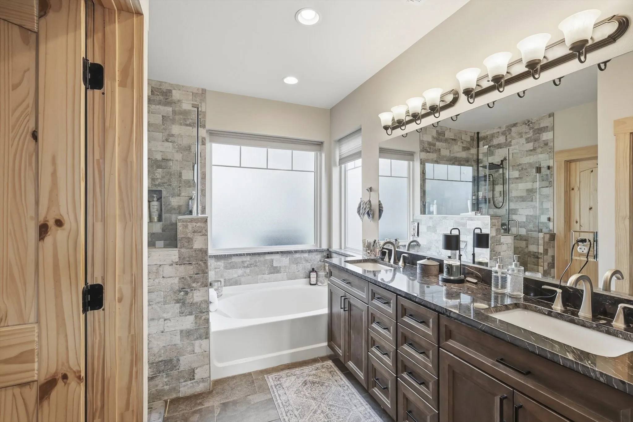 Bathroom with double vanity, a bath, a stall shower, and recessed lighting