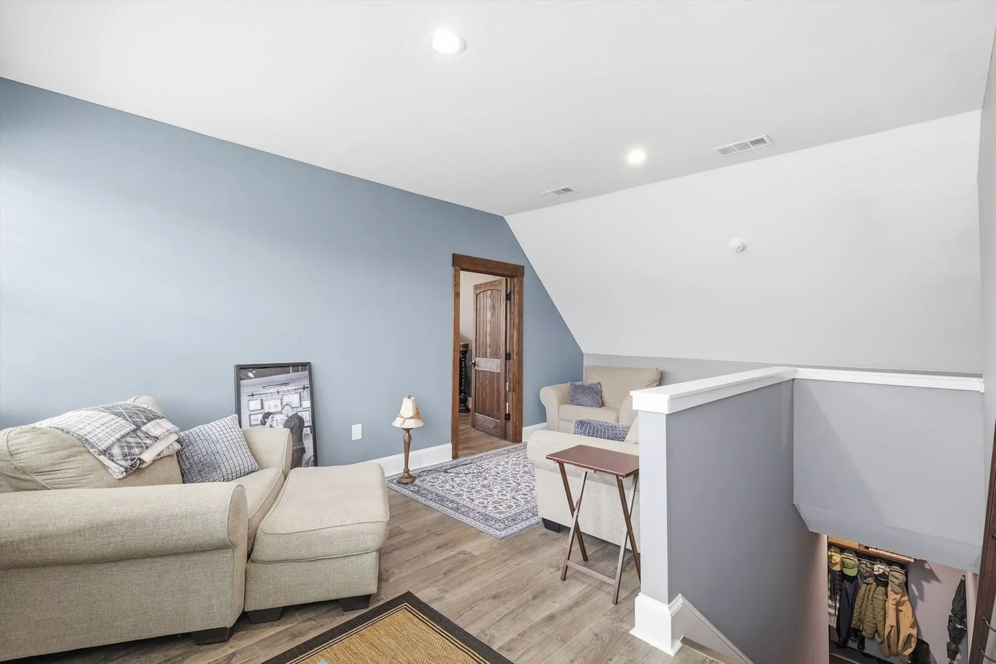 Living area featuring recessed lighting, an upstairs landing, wood finished floors, and vaulted ceiling