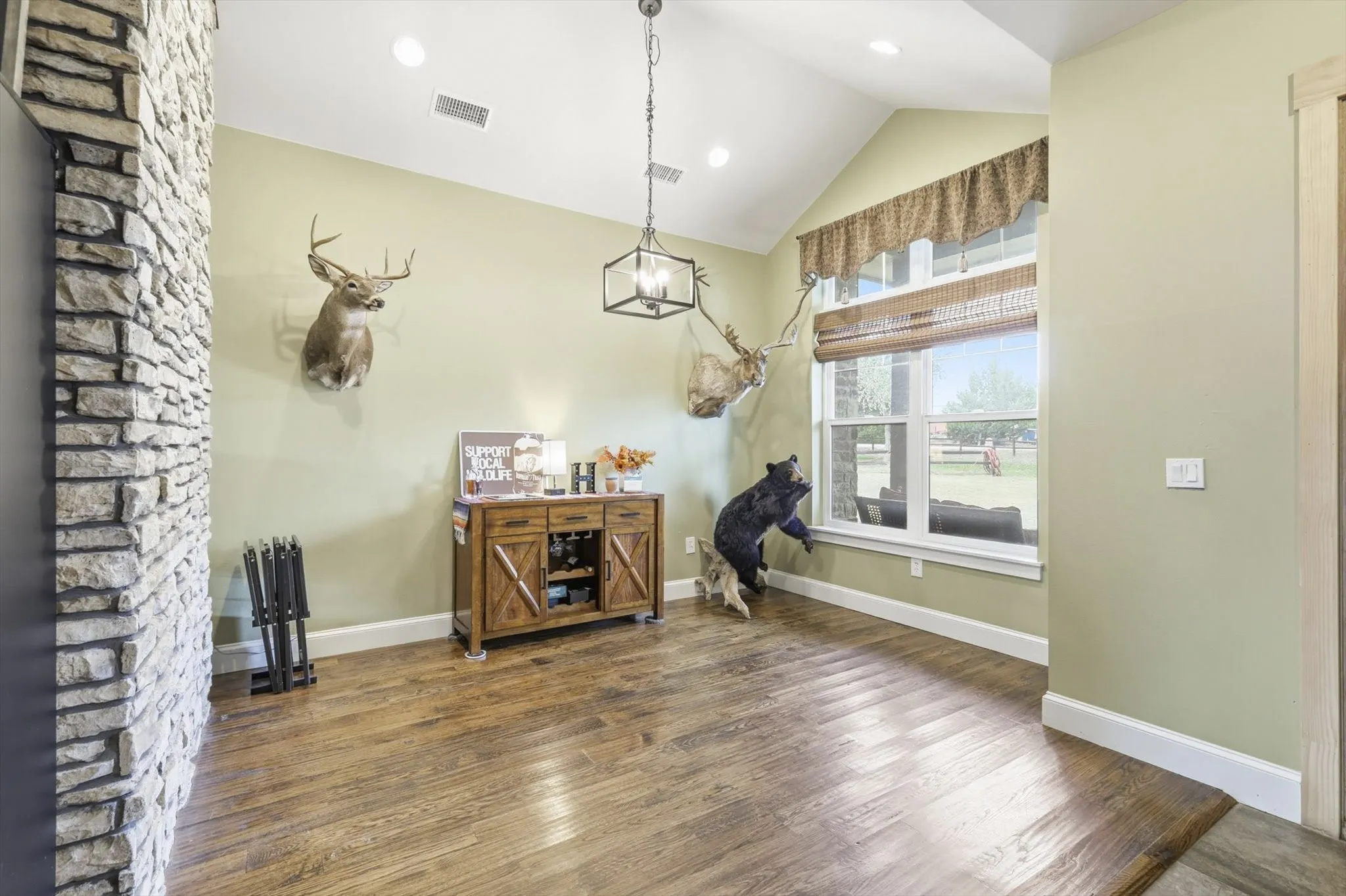 Dining area featuring wood finished floors and high vaulted ceiling