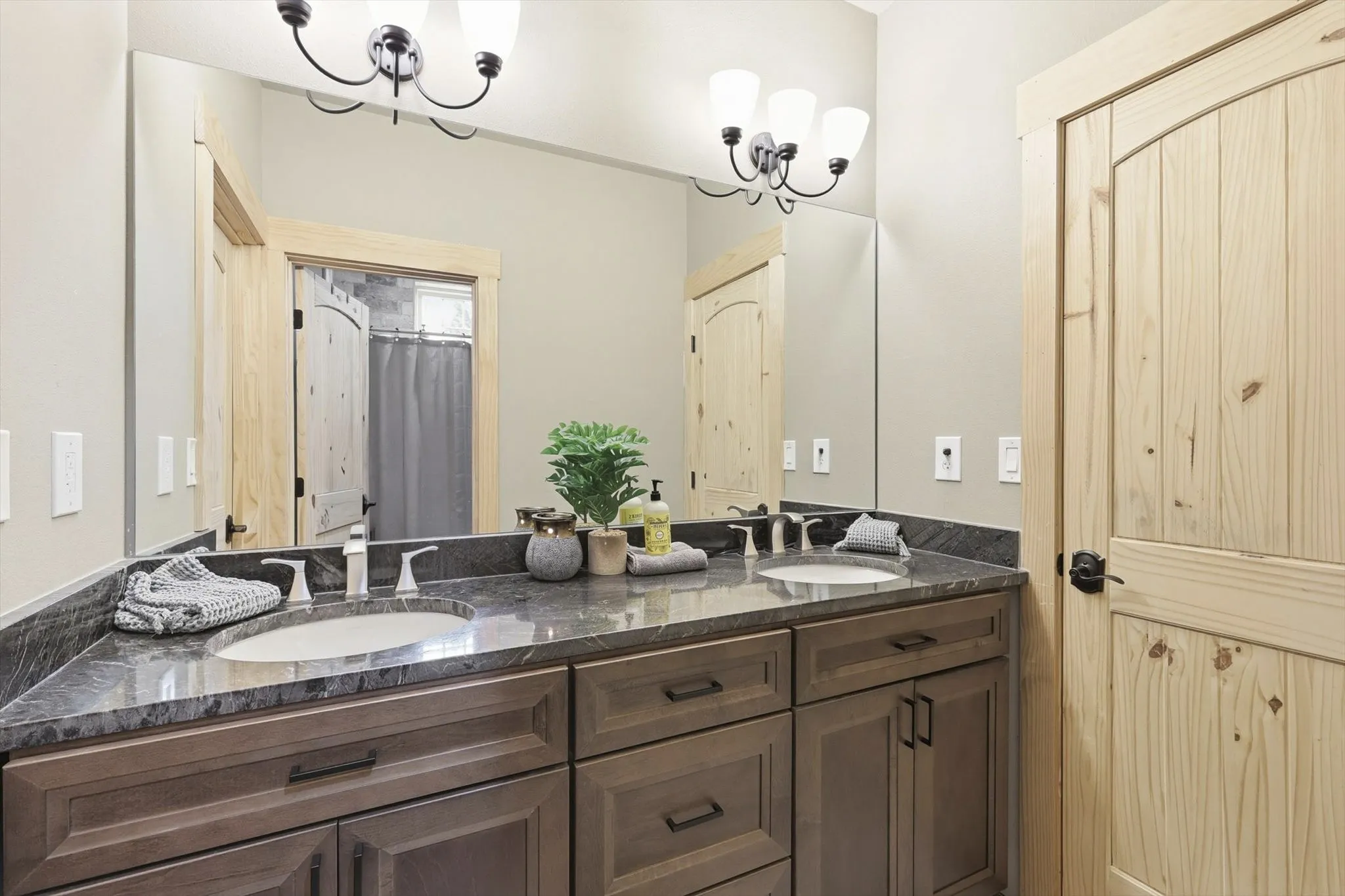 Bathroom featuring double vanity, a chandelier, and a shower with shower curtain