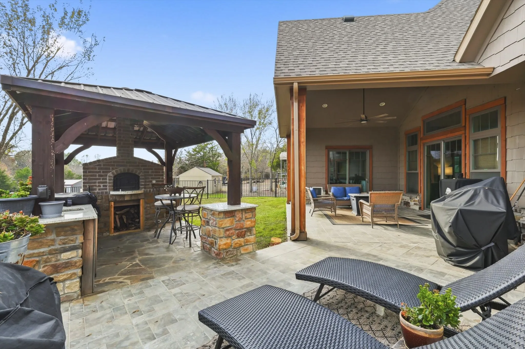 View of patio / terrace featuring a ceiling fan, an outdoor living space with a fireplace, a gazebo, and a grill