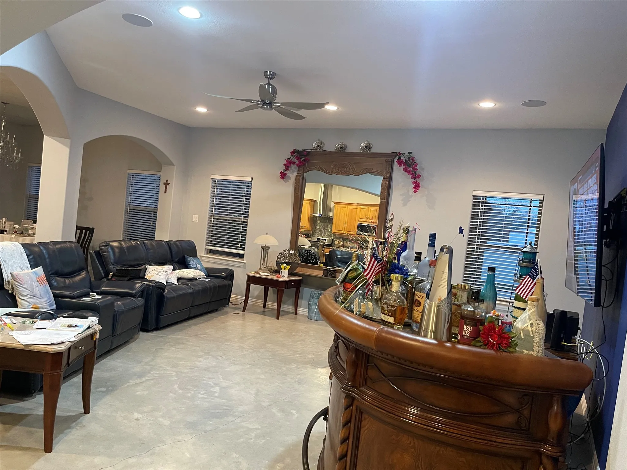 Living area featuring a ceiling fan, arched walkways, and recessed lighting
