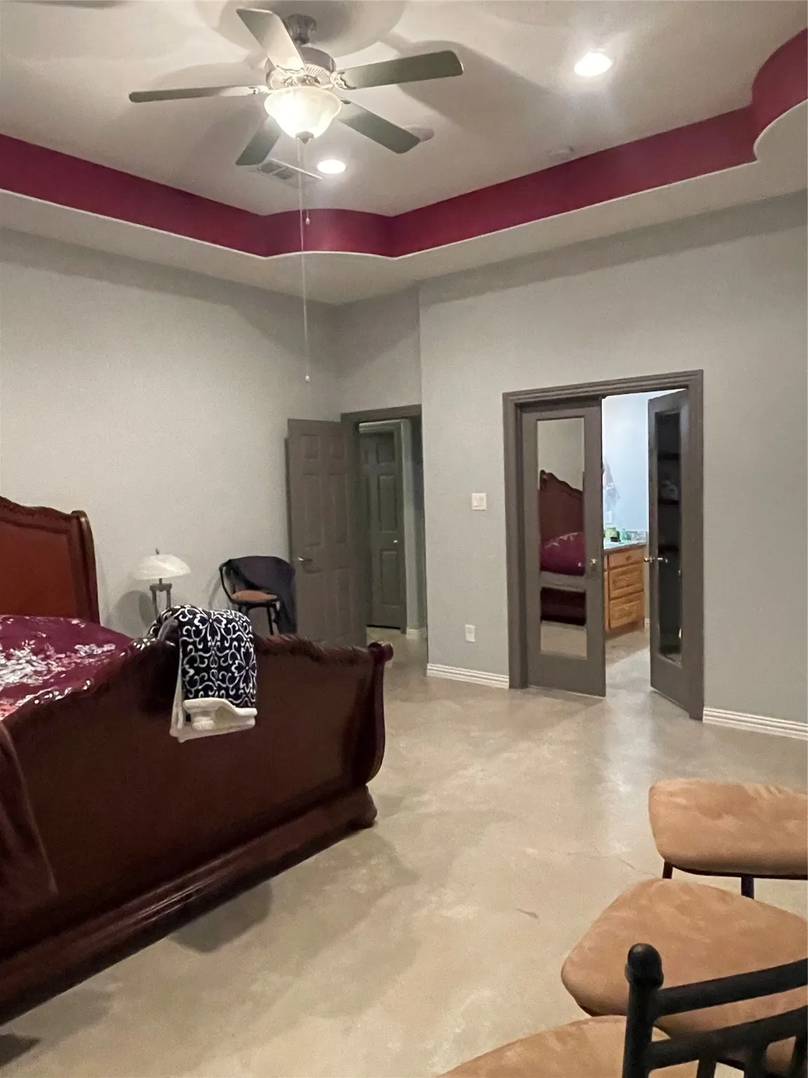 Bedroom featuring a raised ceiling, recessed lighting, ceiling fan, and concrete floors